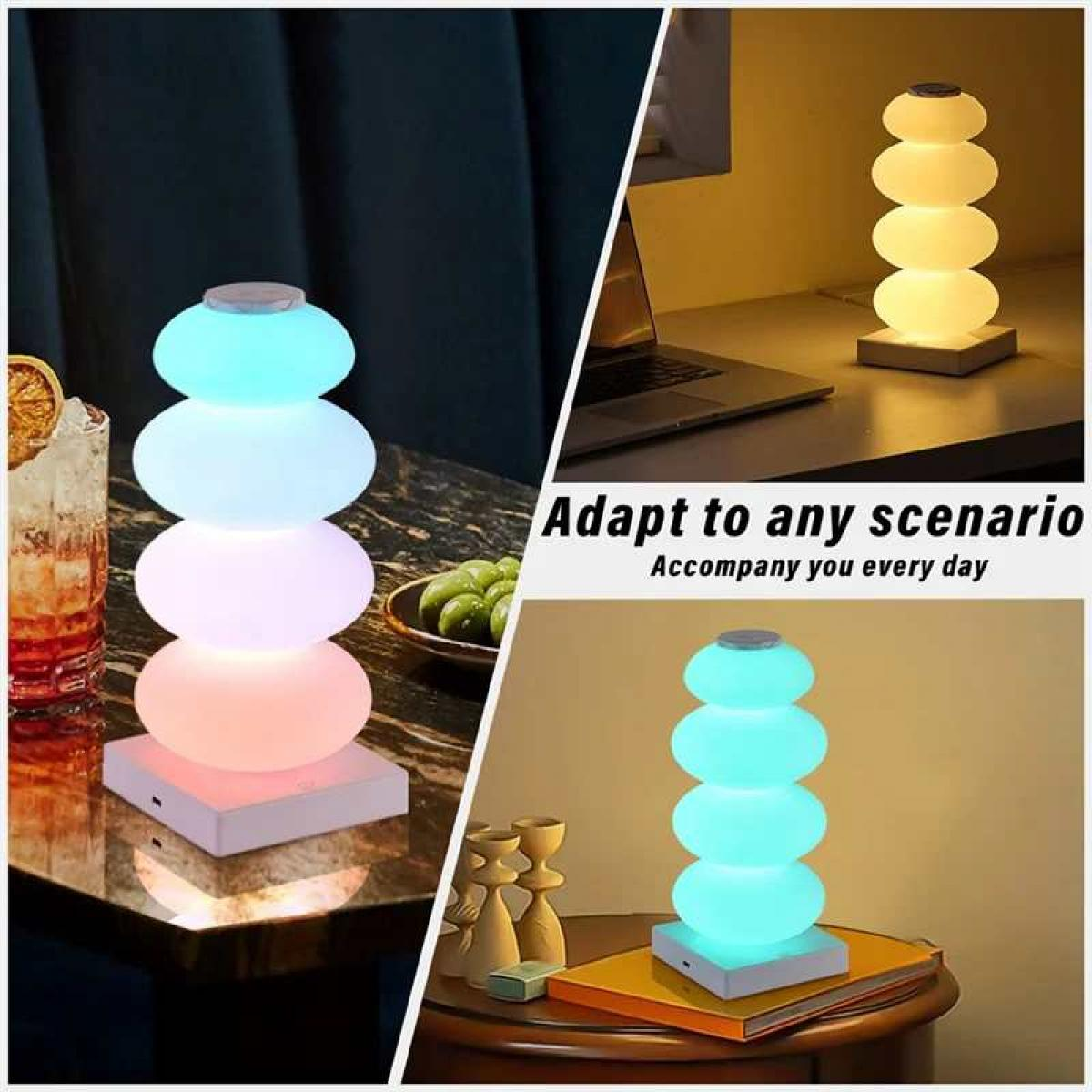 Eine stapelbare, mehrfarbige LED-Lampe steht neben einem Getränk auf einem Tisch und auf einem Schreibtisch.