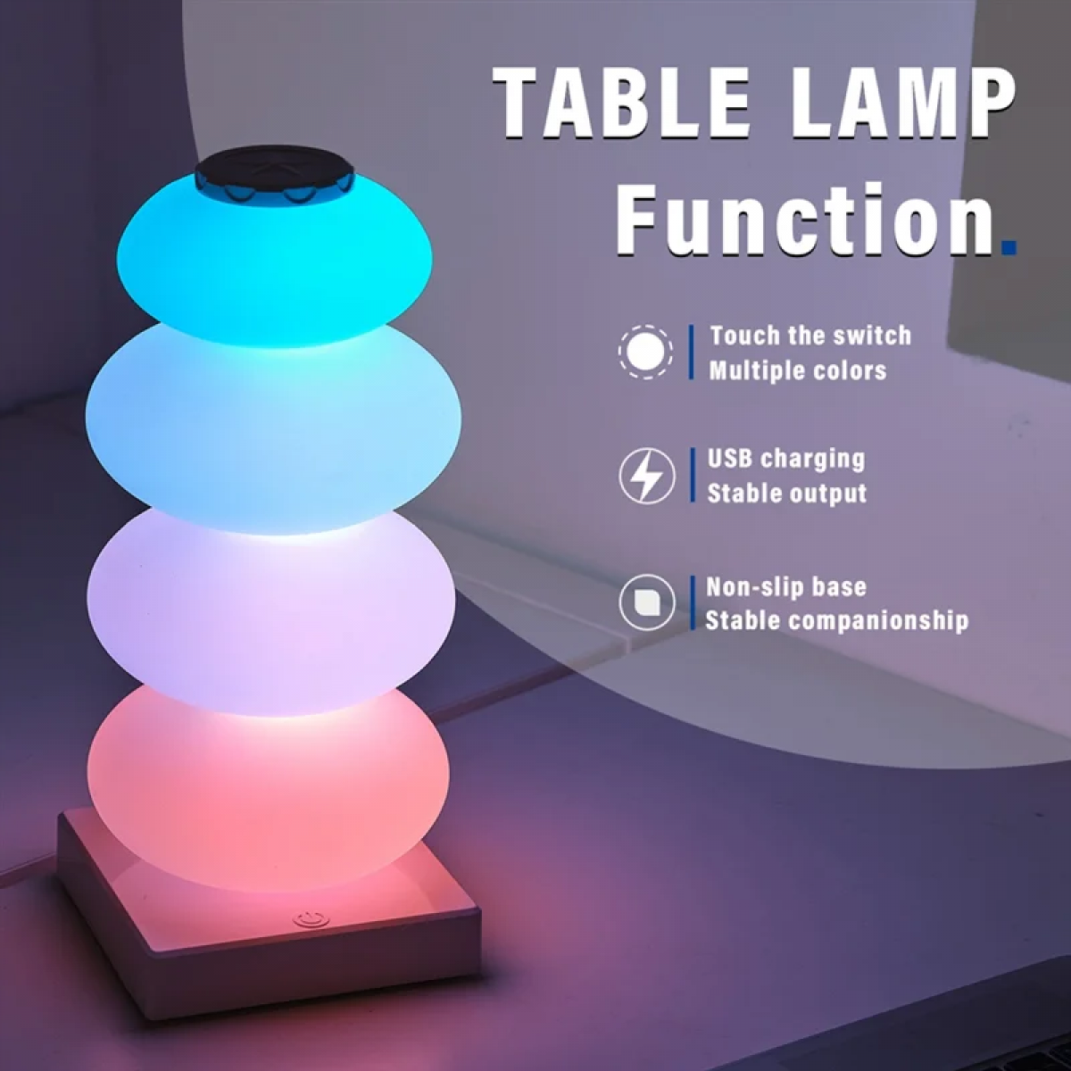 Eine gestapelte, steinförmige Lampe mit blauem, weißem und rosa Licht steht auf einem Schreibtisch.