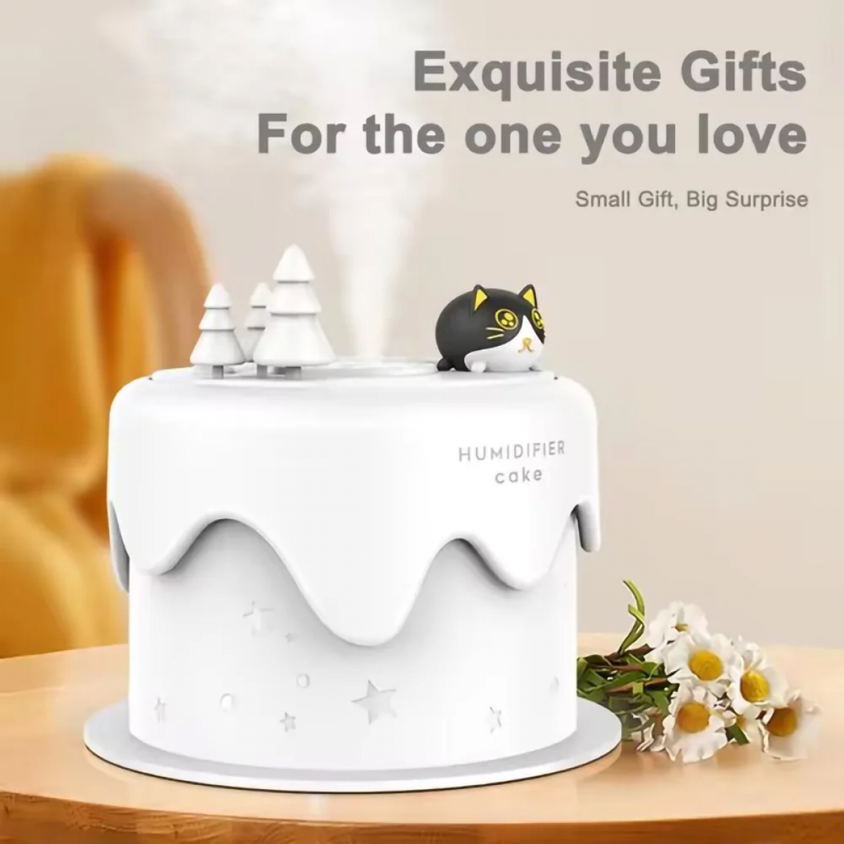 Ein weißer Luftbefeuchter in Kuchenform mit einem Katzenmotiv, Bäumen und Dampf.
