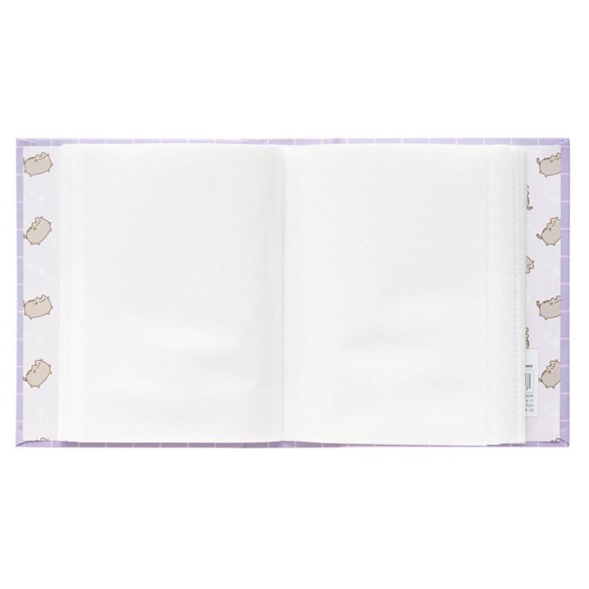 Un album ouvert avec une couverture violette à carreaux décorée de Pusheen.