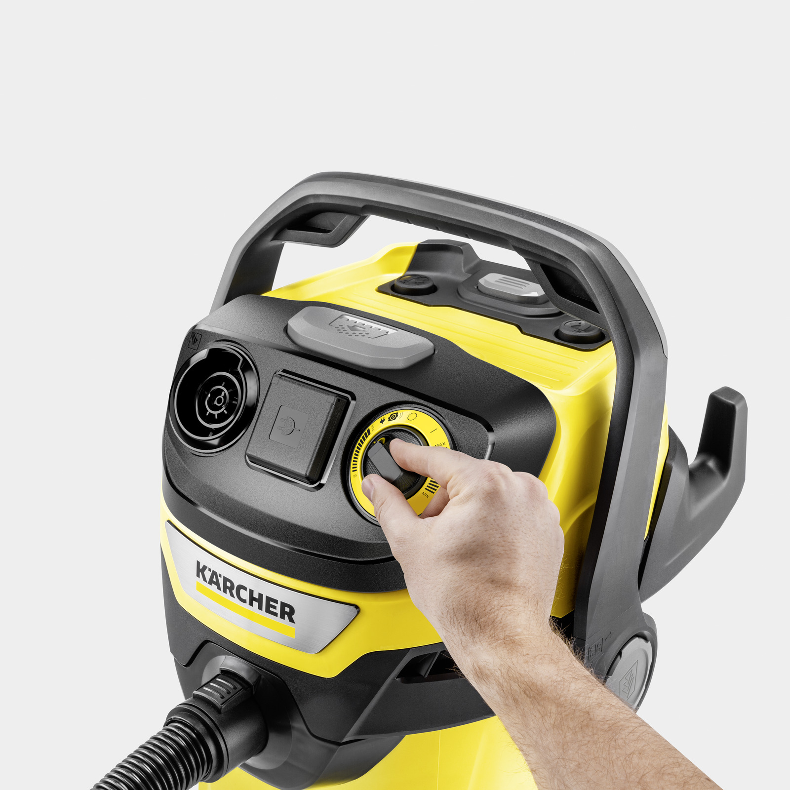 Una mano gira una manopola nera su un aspirapolvere Karcher giallo.