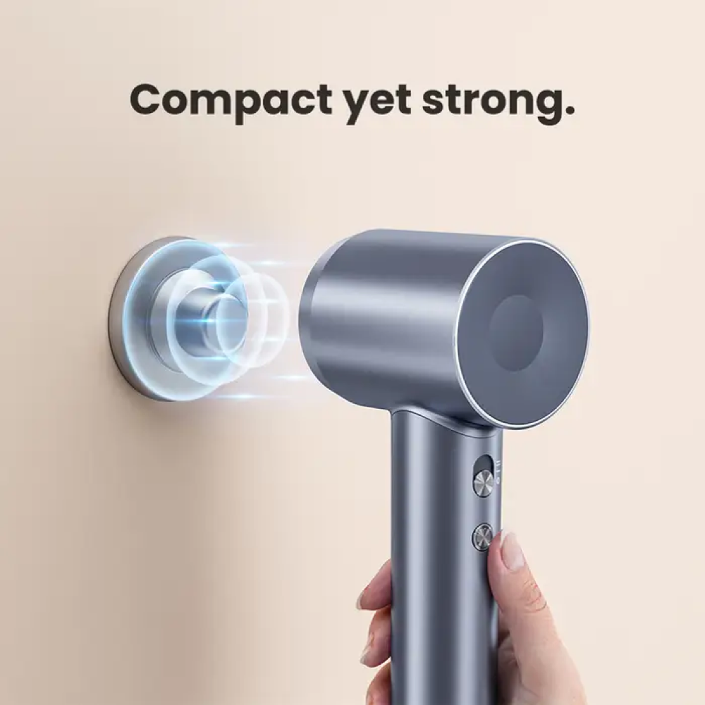 Un asciugacapelli grigio è tenuto vicino a un supporto a muro con effetti di luce blu.