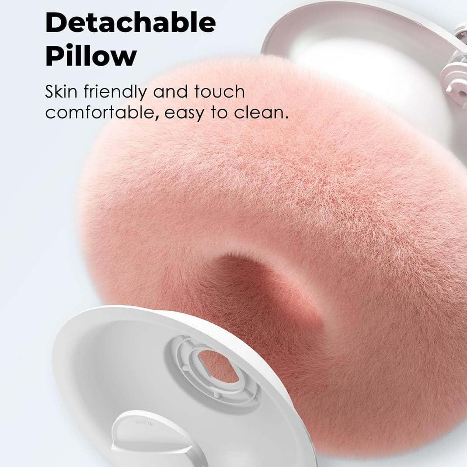 Nahaufnahme eines abnehmbaren Reisekissens aus rosa Flausch mit weißer Basis.