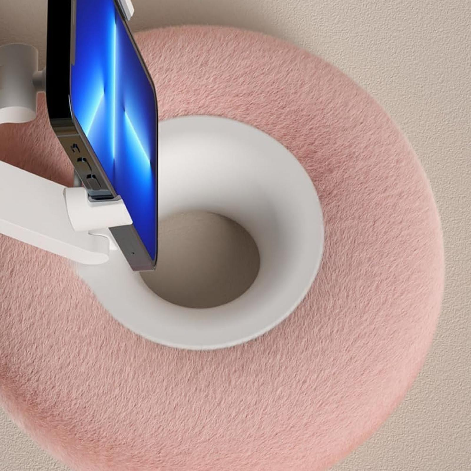 Ein Smartphone ist auf einem weißen Arm über einem pinken, flauschigen, kreisförmigen Objekt montiert.