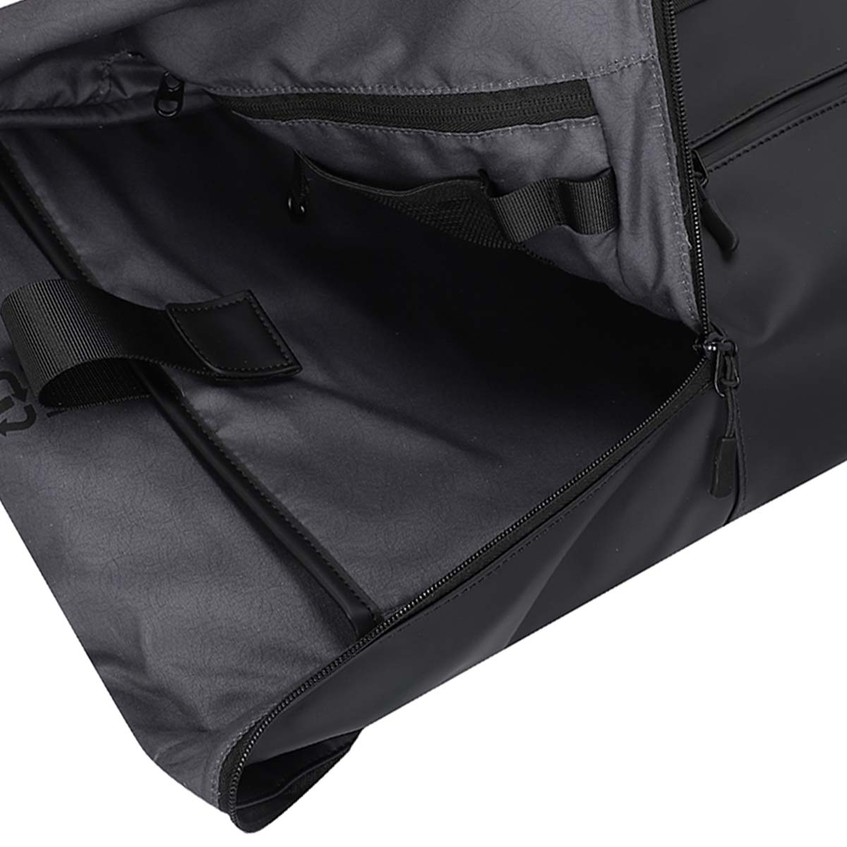 Vista interna di una borsa nera con scomparti organizzati e cerniere.