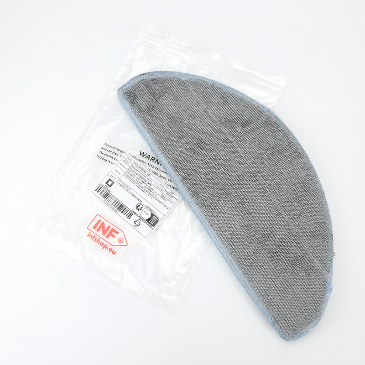 Szara, półokrągła nakładka czyszcząca znajduje się w plastikowym opakowaniu z etykietami ostrzegawczymi.