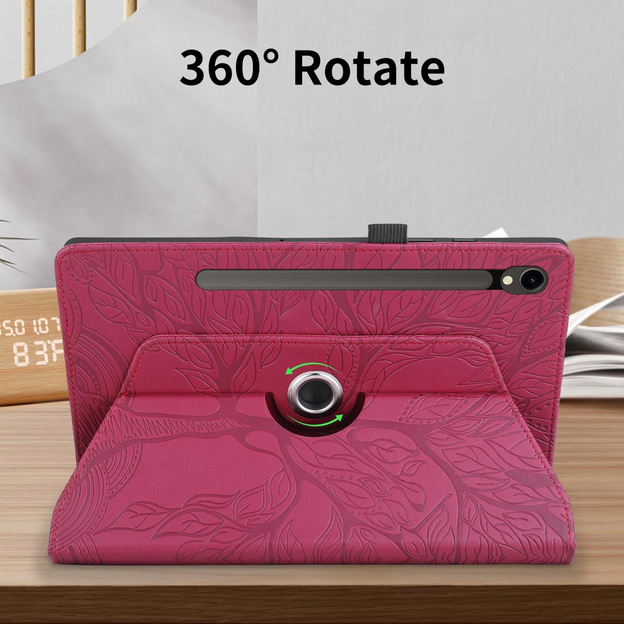 Una custodia rosa per tablet con motivo a foglie su un tavolo di legno.