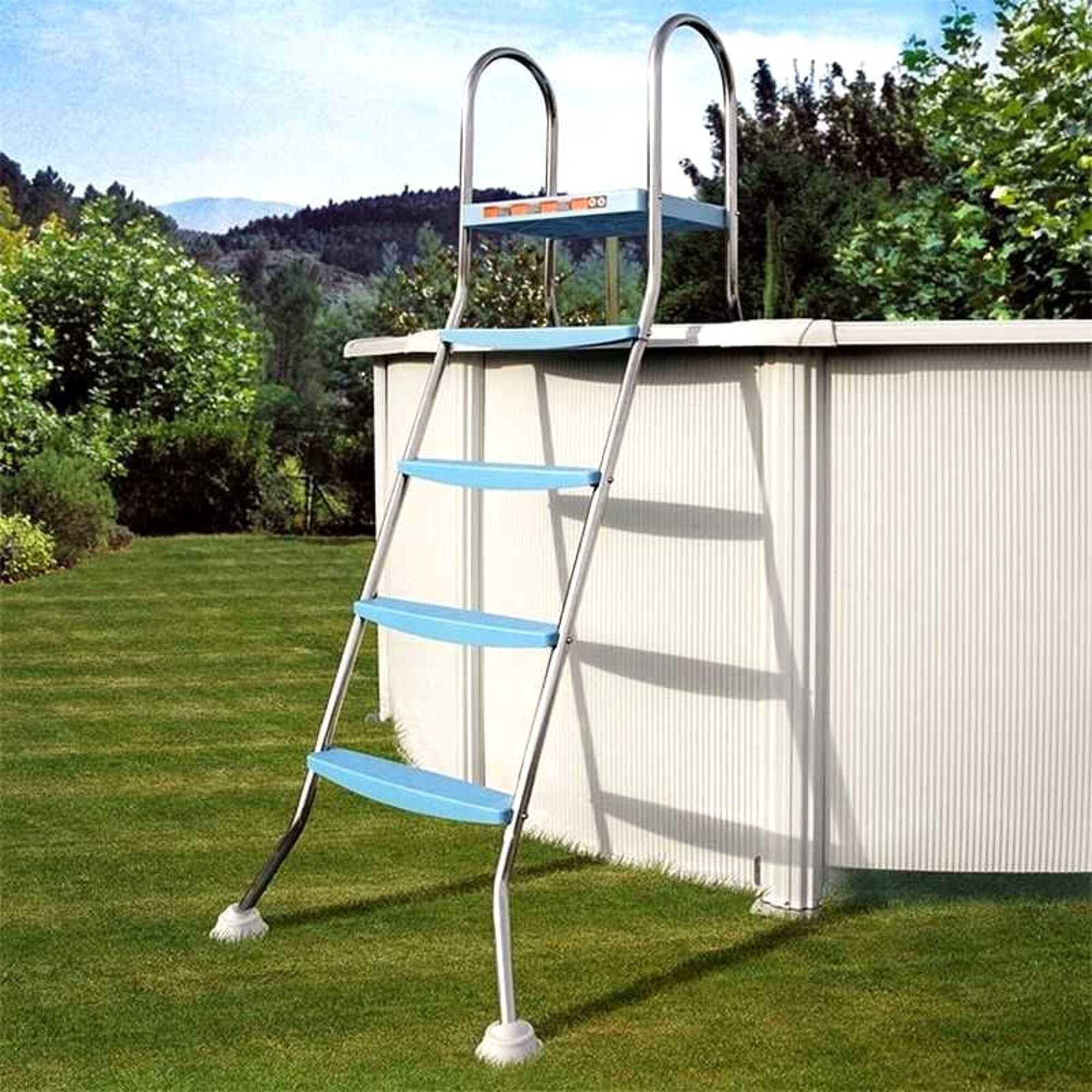 Una escalera de piscina metálica con peldaños azules se encuentra sobre césped verde junto a una piscina blanca.