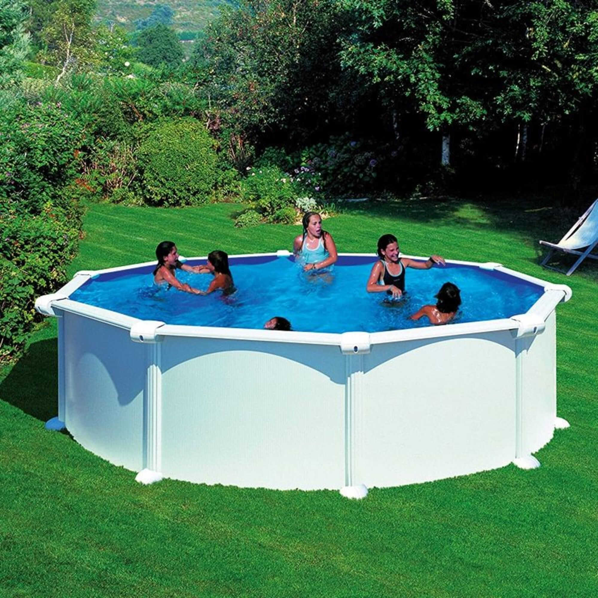 Los niños nadan en una gran piscina elevada octogonal en un día soleado.