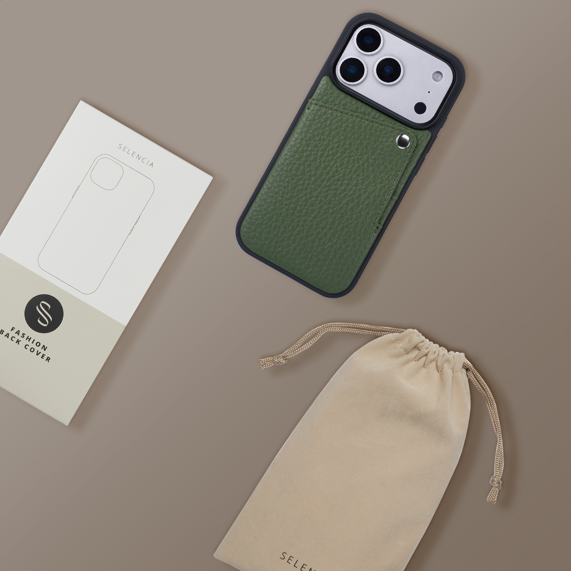 Coque de téléphone en cuir vert avec découpe caméra, emballage et pochette cordon sur fond brun.