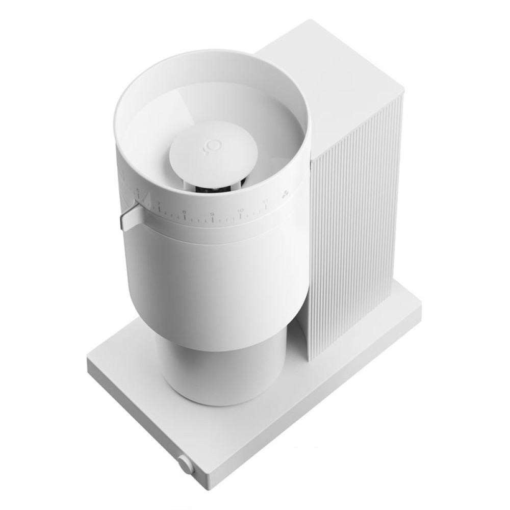 Biały młynek do kawy z cylindrycznym zasobnikiem i żebrowanym korpusem, na białej podstawie.