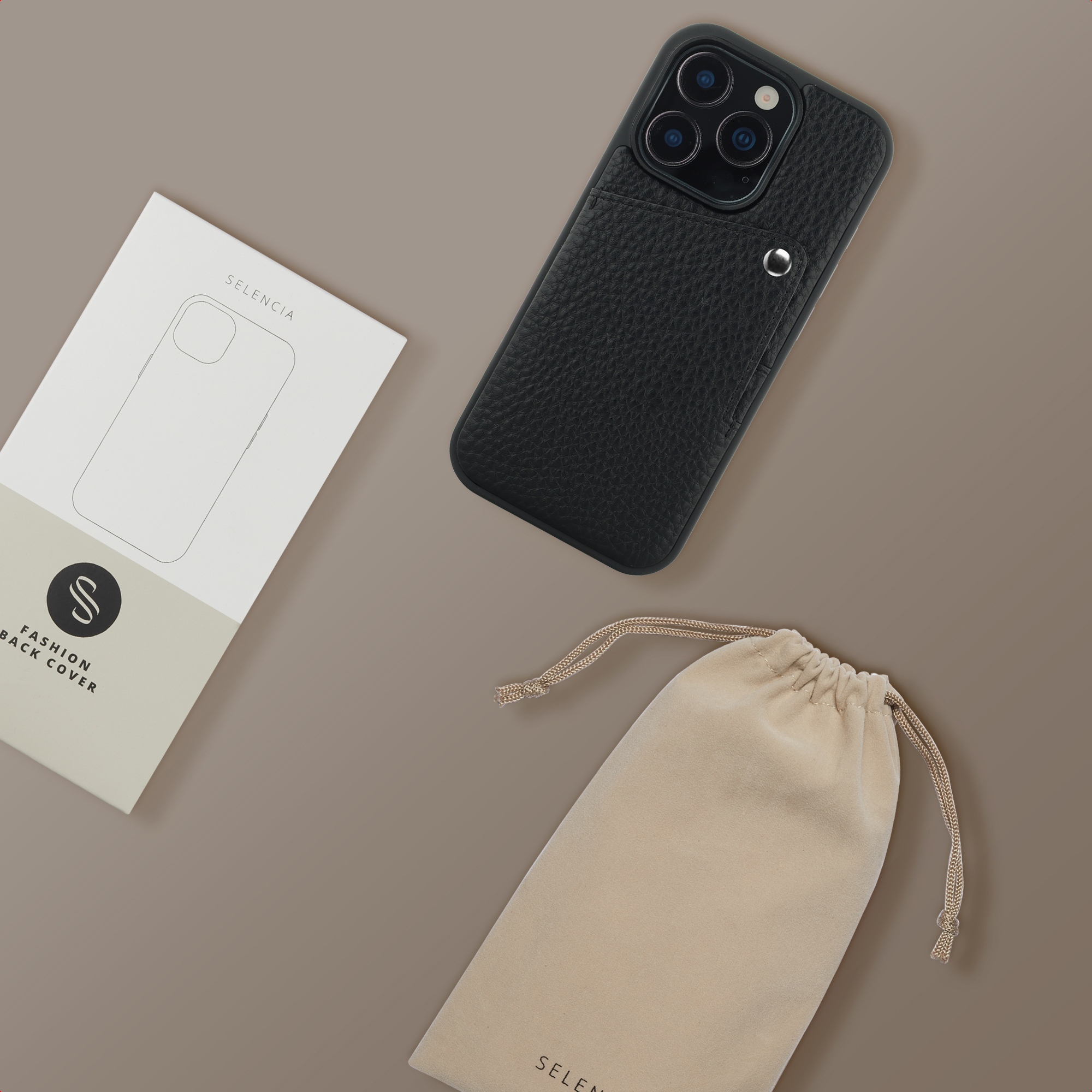 Schwarze Lederhülle, Verpackung und beige Tasche auf braunem Hintergrund.
