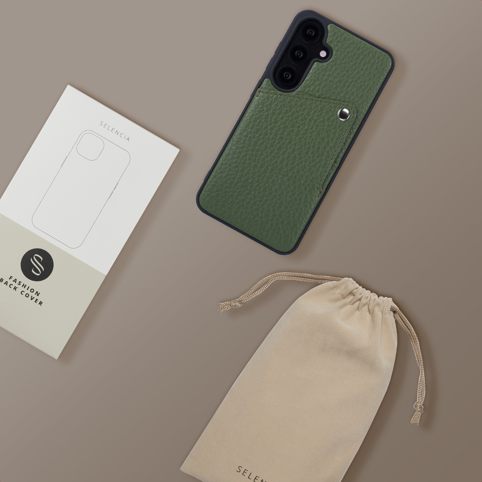 Une coque de téléphone en cuir vert, un emballage et une pochette à cordon sur fond brun.