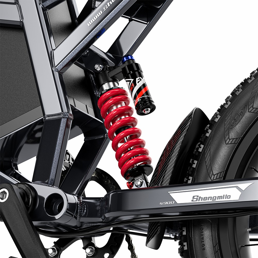 Primer plano del sistema de suspensión trasera de una bicicleta eléctrica con amortiguador de muelle rojo.