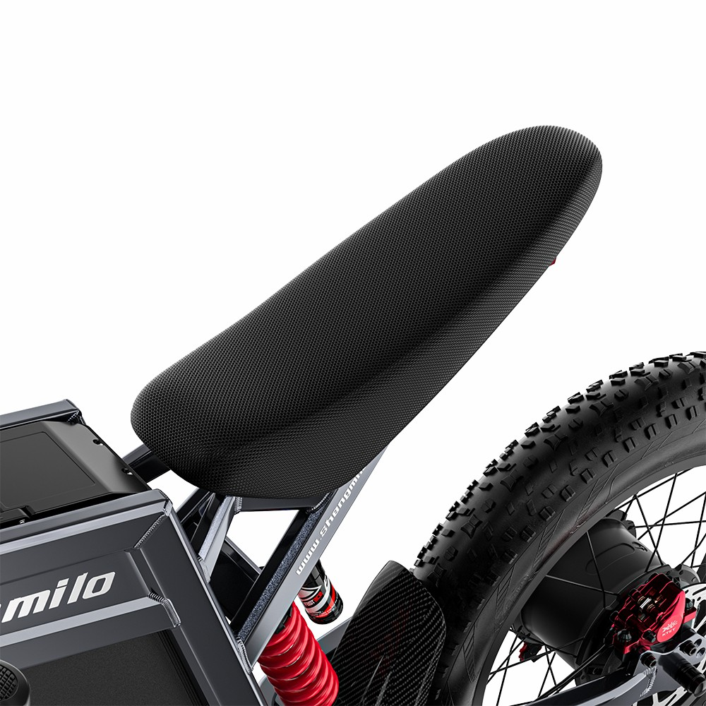 Primer plano de un asiento de e-bike negro con suspensión roja y llanta gruesa.