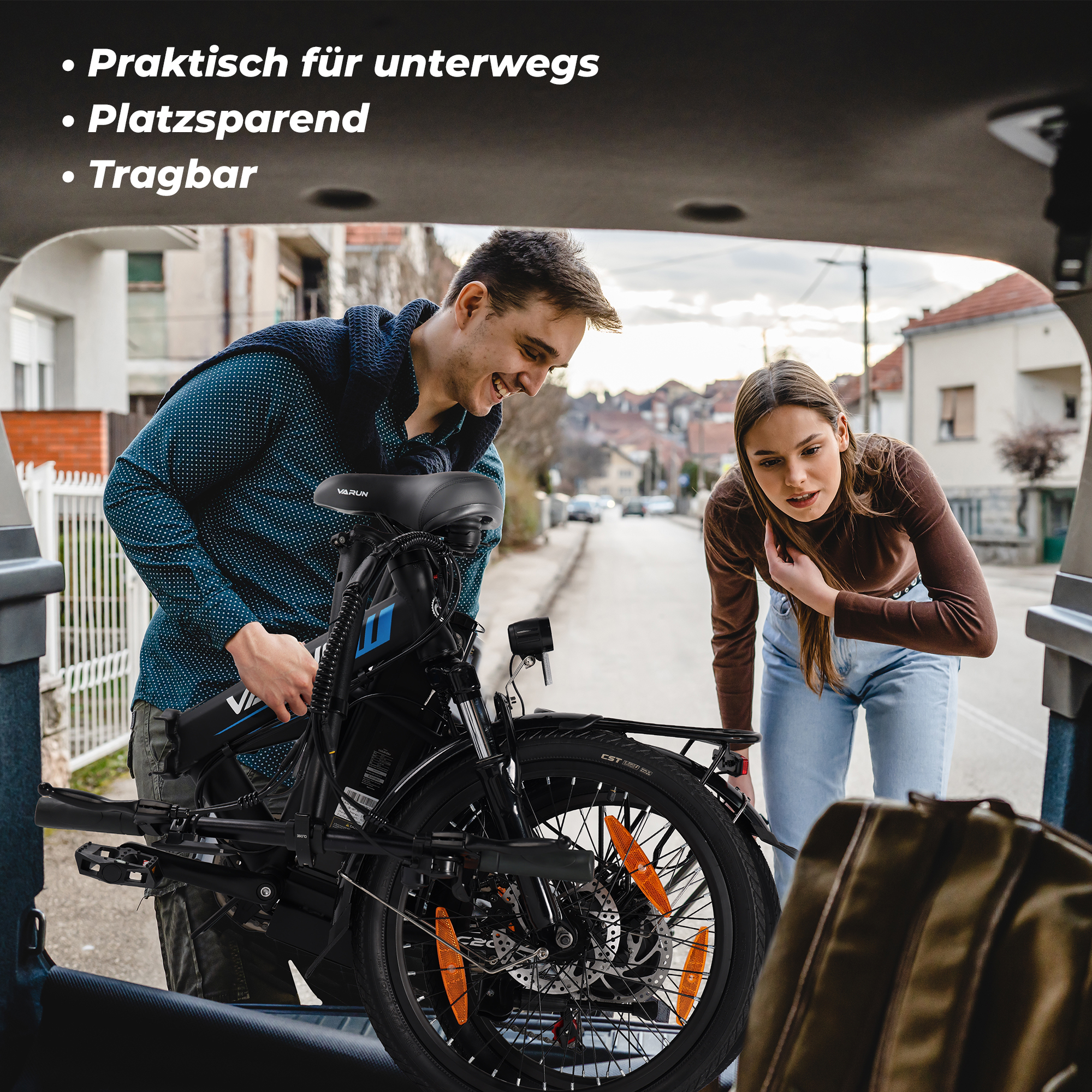 Un hombre y una mujer cargan una bicicleta eléctrica plegable negra en el maletero de un coche. Escena callejera.