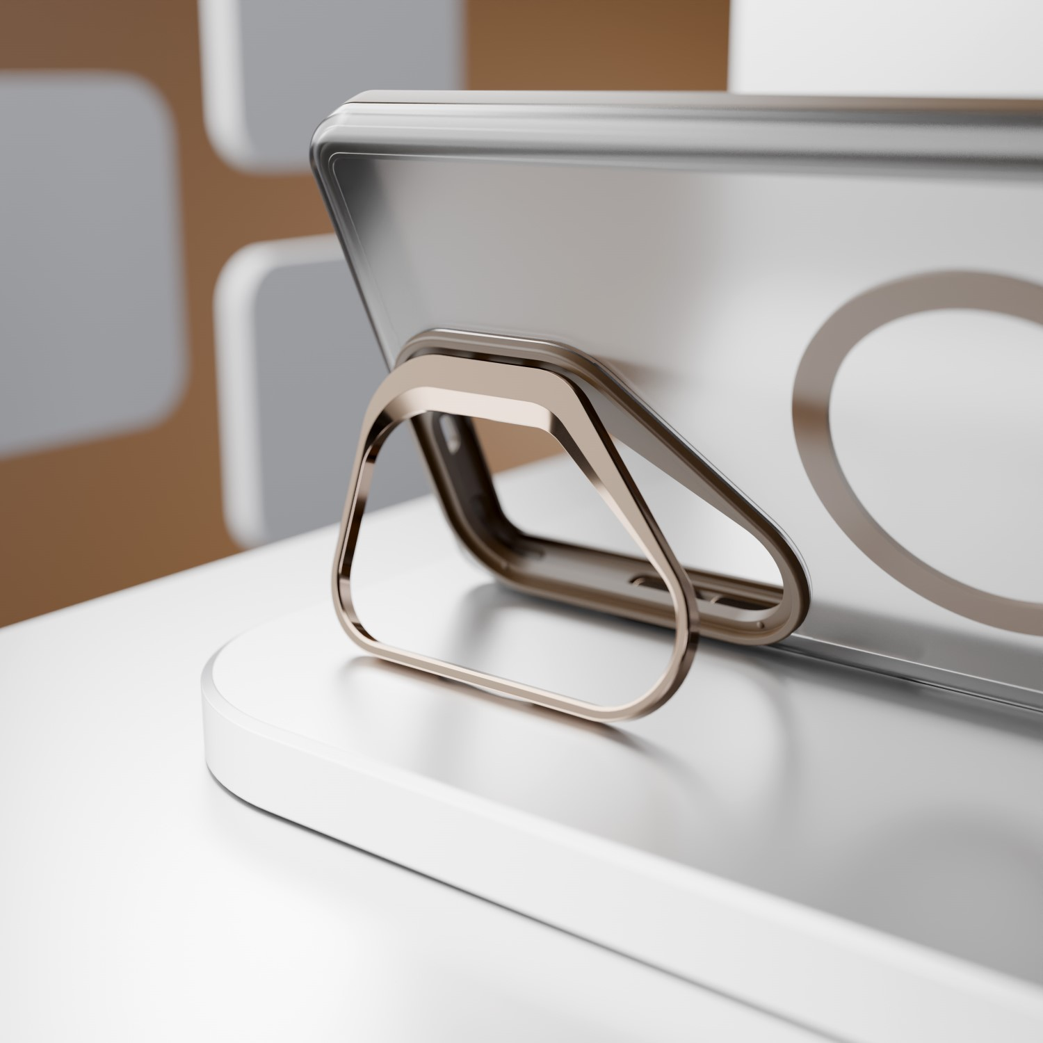 Uno smartphone argentato con un supporto ad anello dorato è su un supporto bianco.