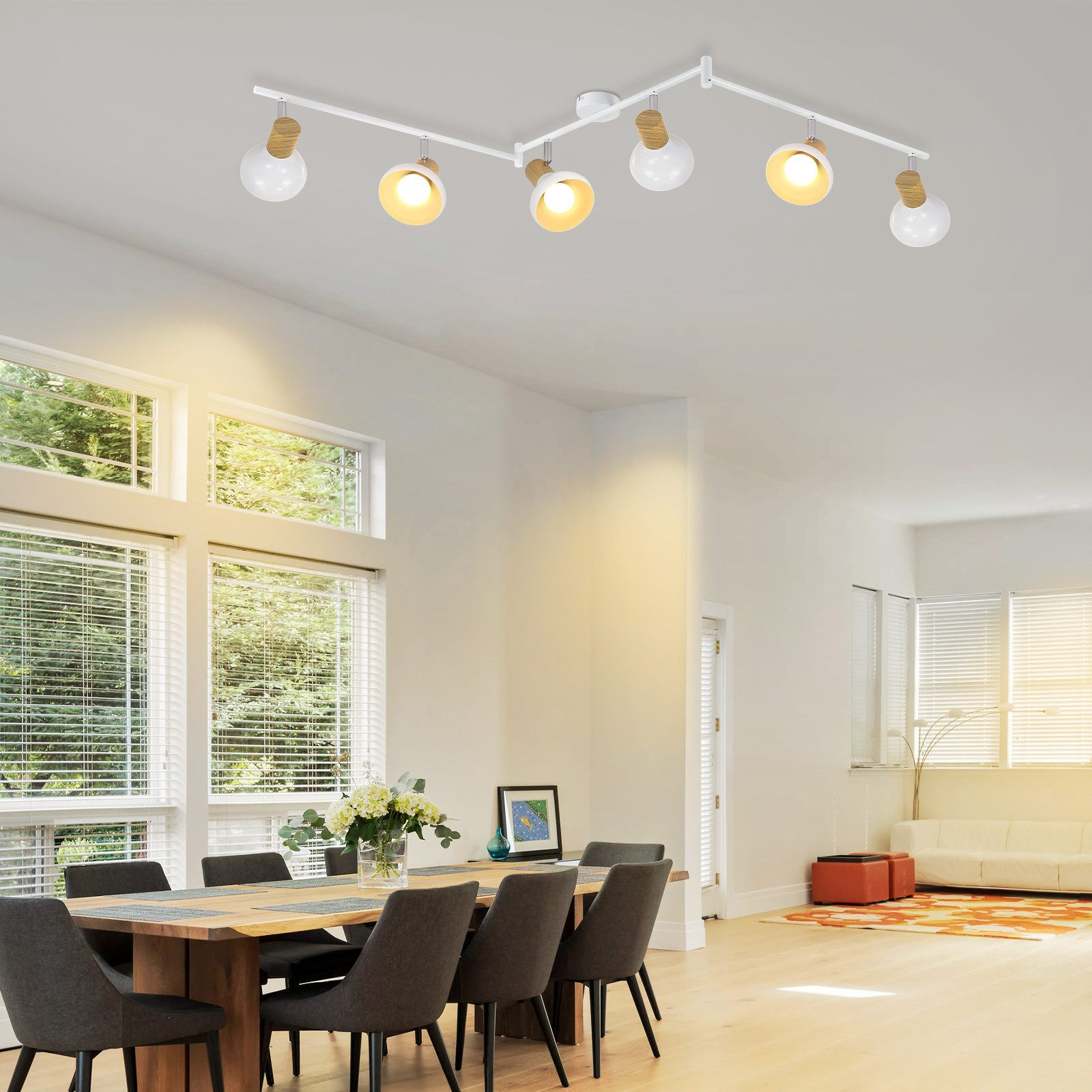 Moderna zona pranzo con tavolo in legno, sedie e lampada da soffitto.