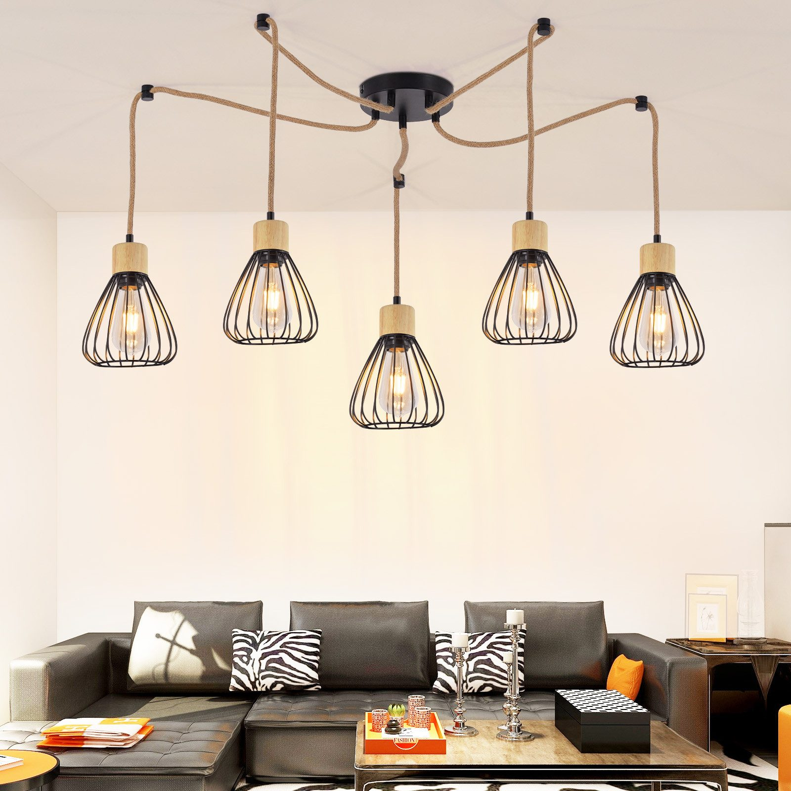 Wisząca lampa z pięcioma kloszami w kształcie klatki wisi nad czarną skórzaną sofą.
