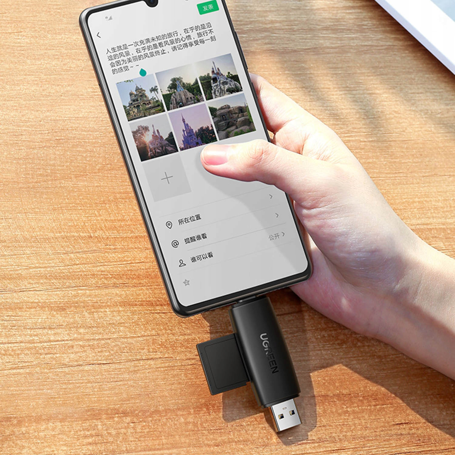 Dłoń trzyma smartfon podłączony do pendrive'a USB. Widoczne zdjęcia zamków.