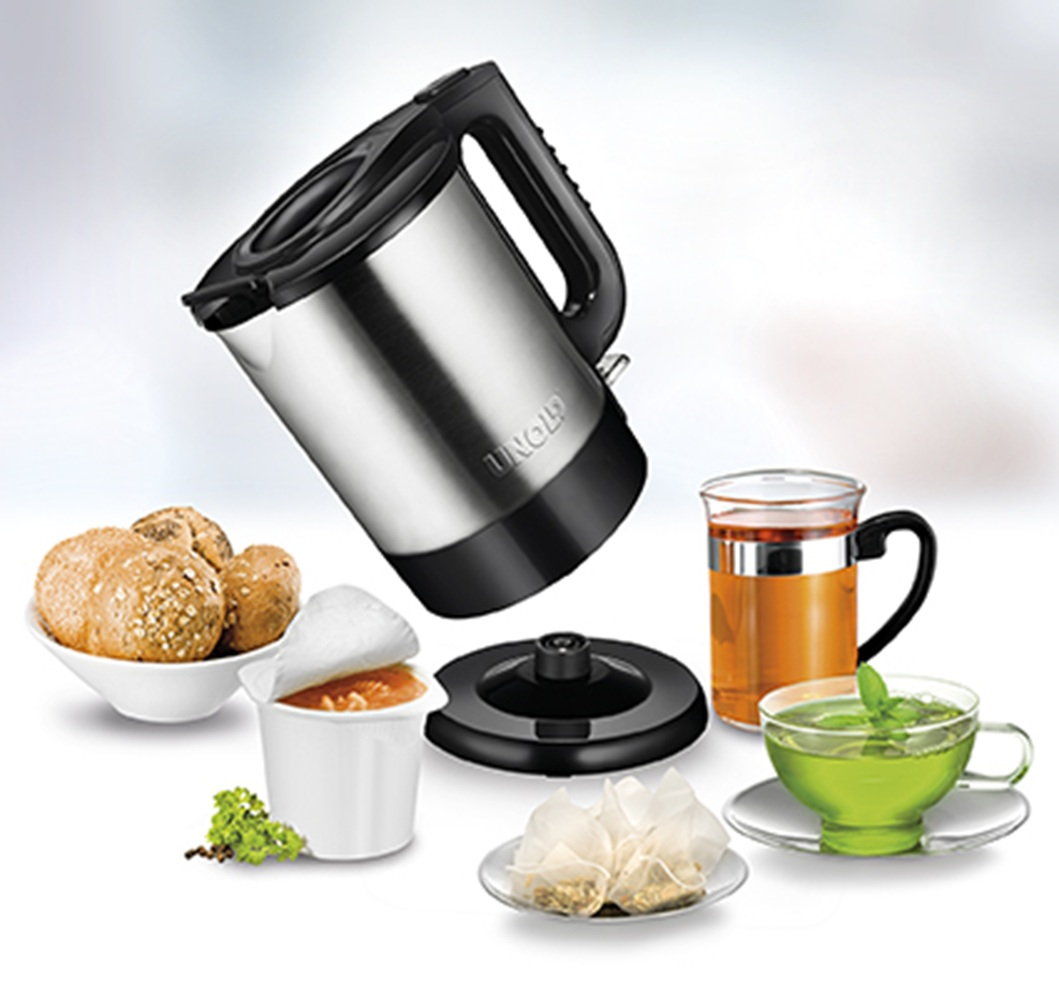 Czajnik ze stali nierdzewnej, bułeczki, zupa, torebki herbaty i dwie filiżanki herbaty.