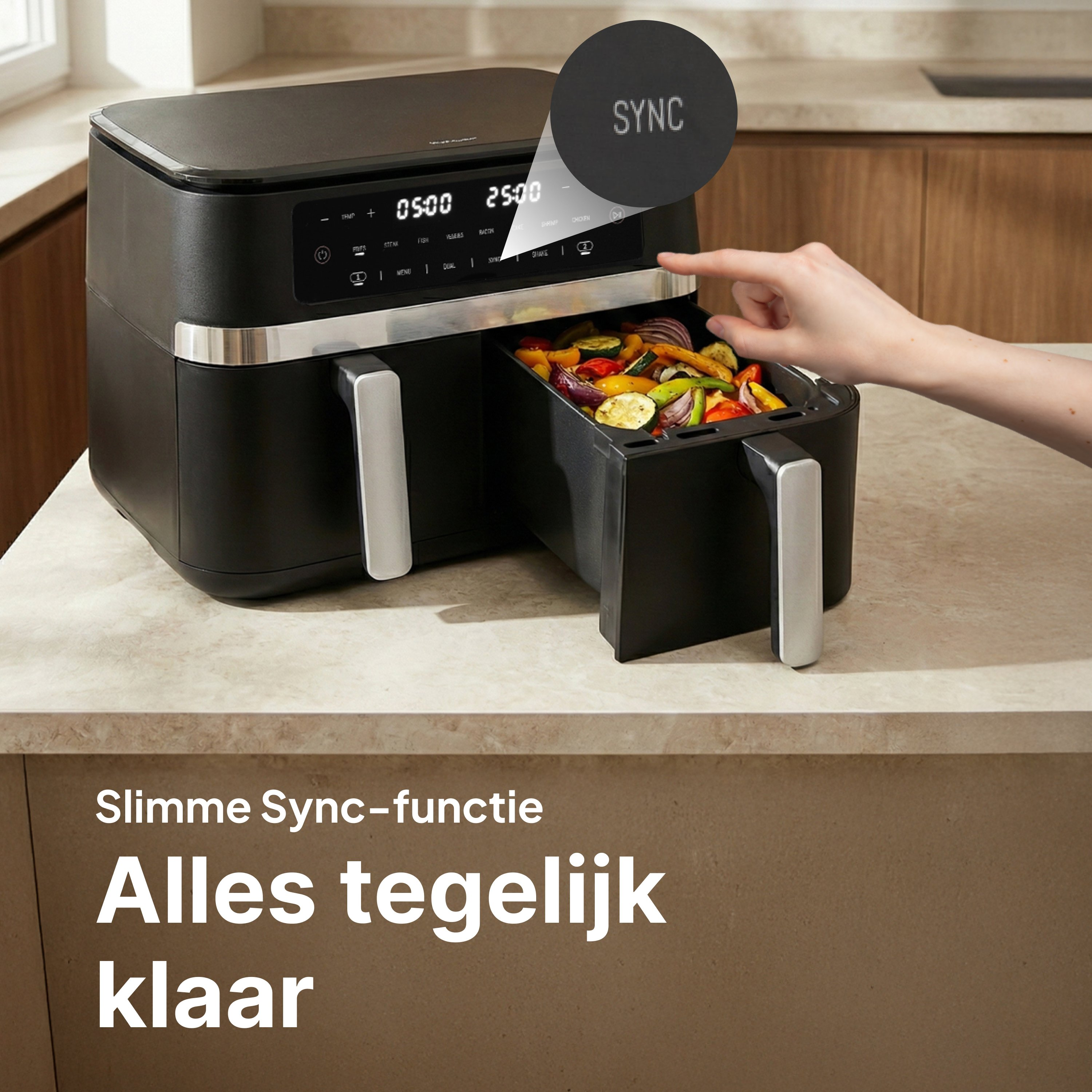 Een zwarte airfryer met een volle lade en een hand die de sync-knop aanraakt.