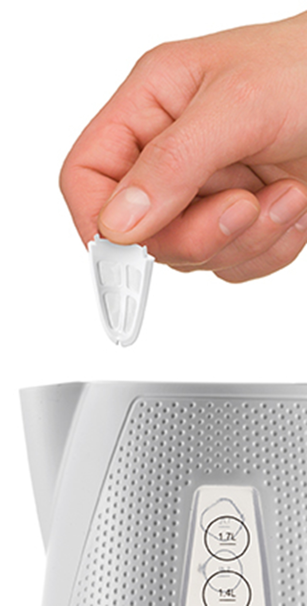 Dłoń trzyma biały filtr nad białym czajnikiem z wskaźnikami poziomu wody.