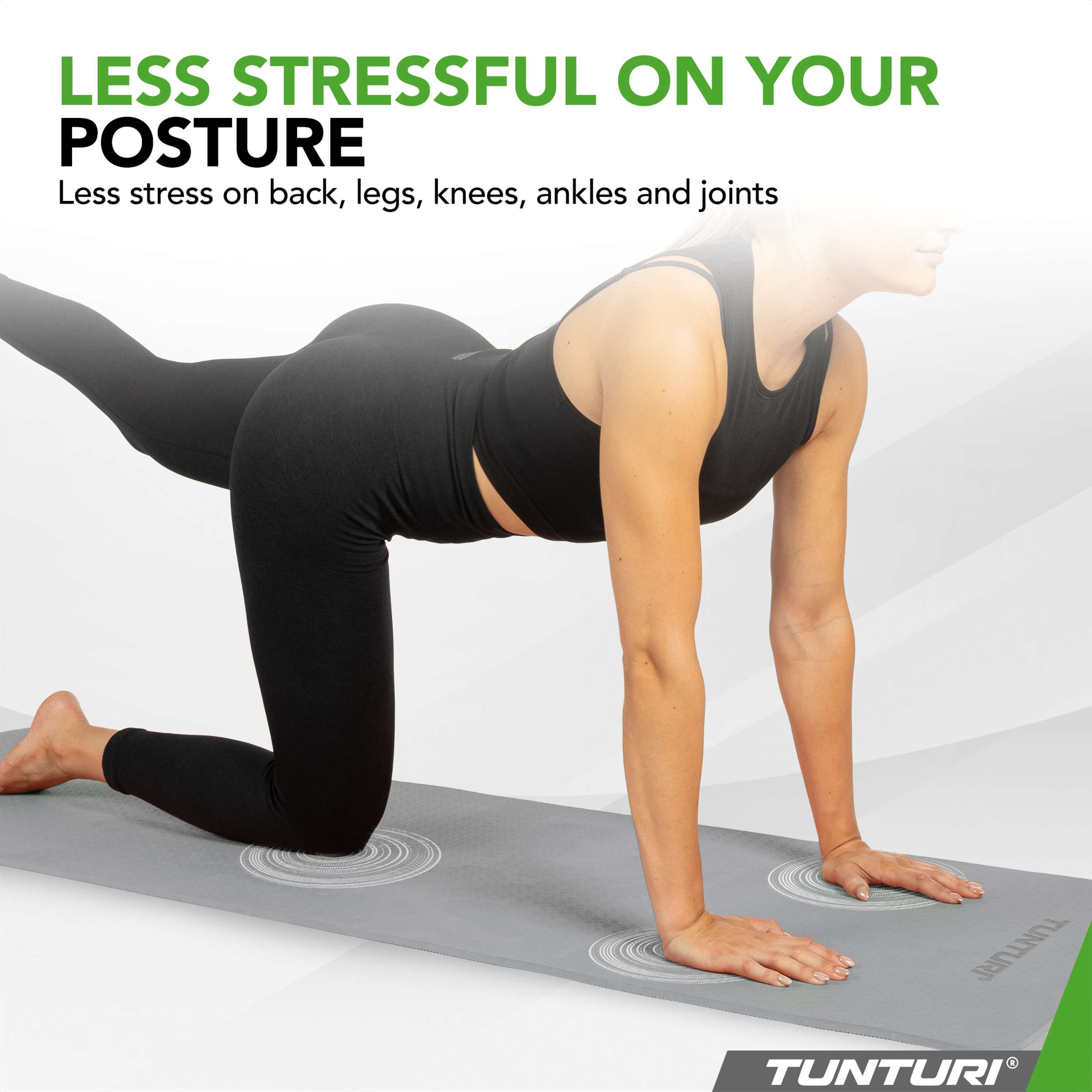 Woman in black activewear on a grey mat, on hands and knees, one leg extended.