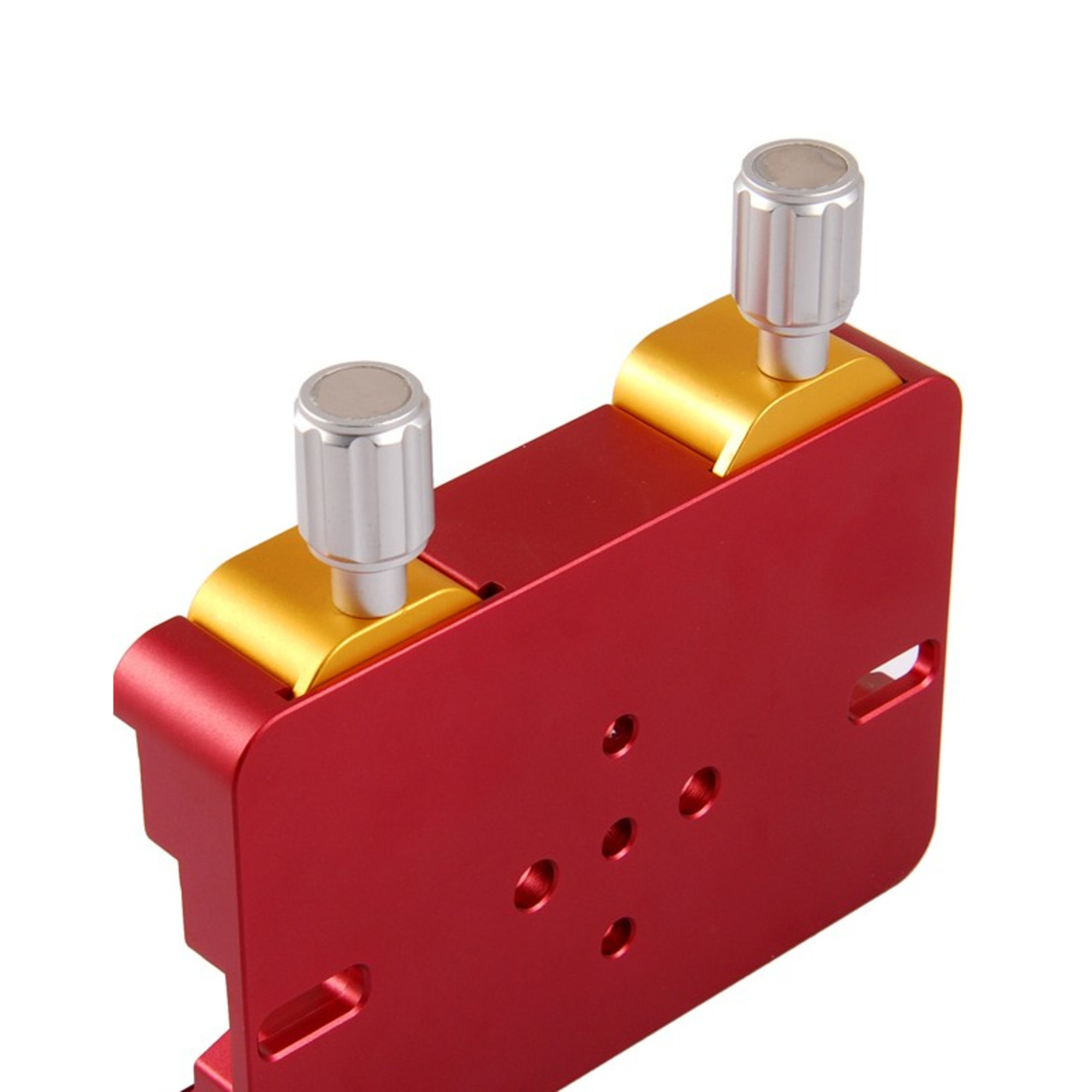 Eine rote Metallklammer mit goldenen Akzenten und zwei silbernen Knöpfen auf weißem Hintergrund.