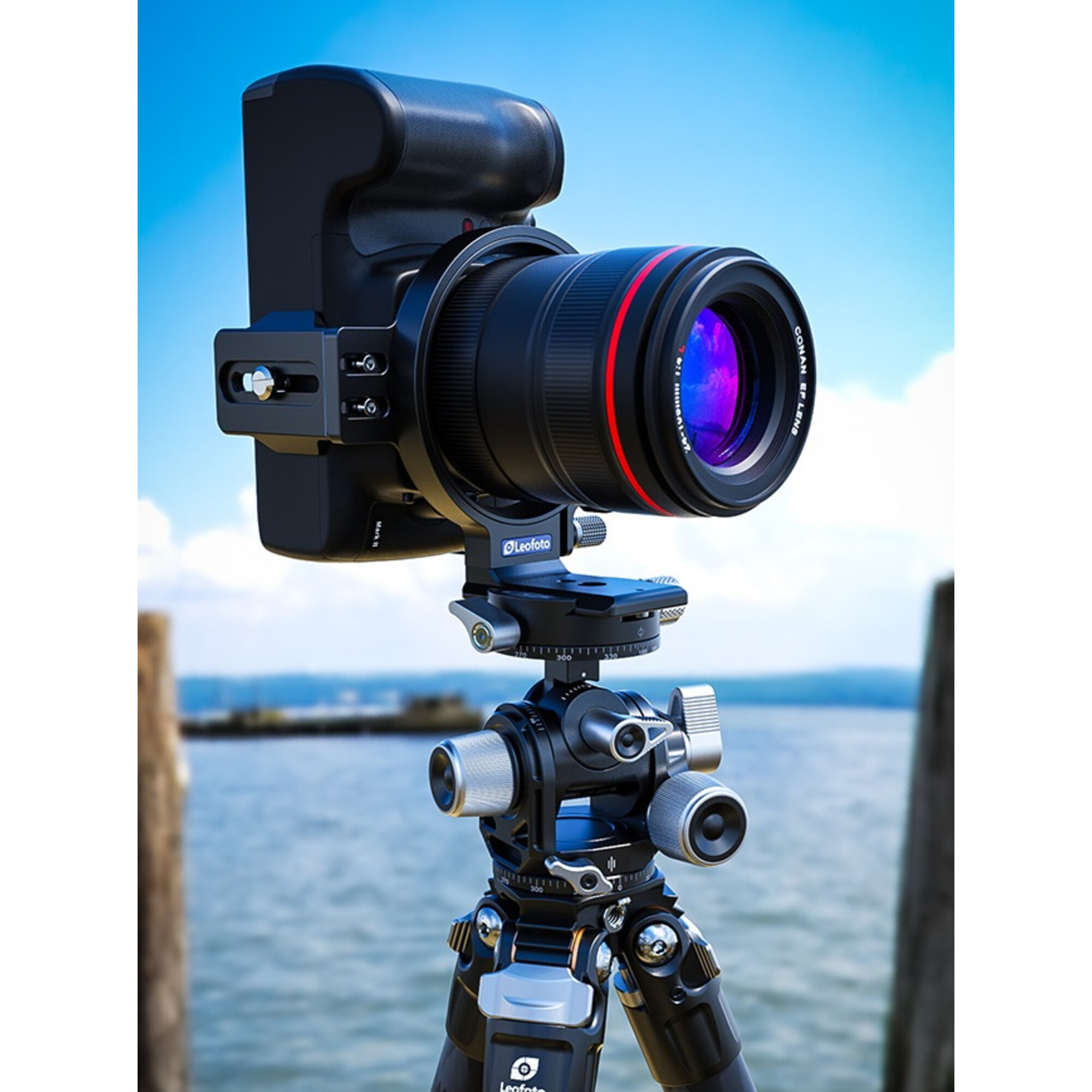 Eine schwarze Kamera mit Objektiv ist auf einem Stativ montiert, mit blauem Himmel und Wasser im Hintergrund.