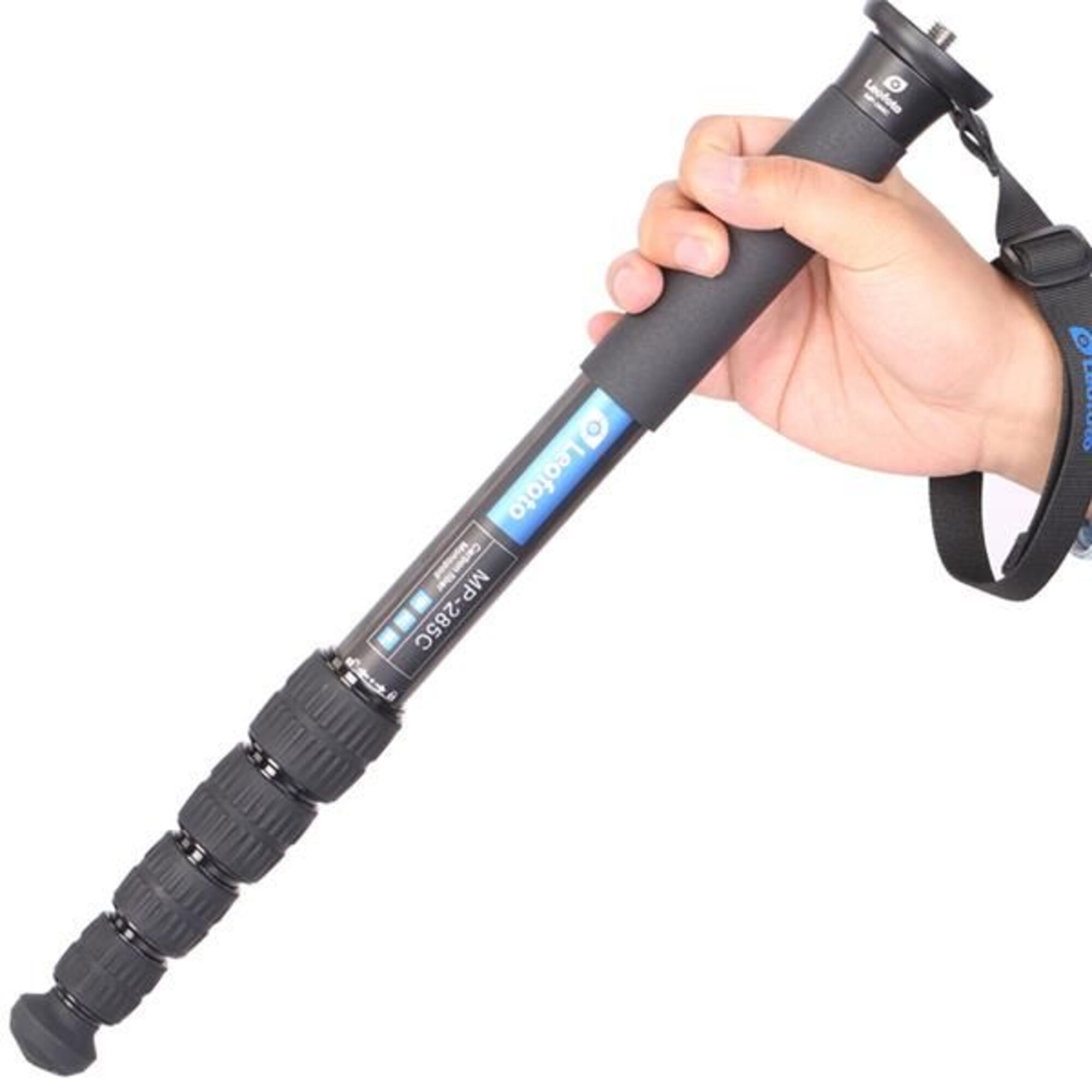 Een hand houdt een zwarte monopod vast met zilveren accenten en polsband.