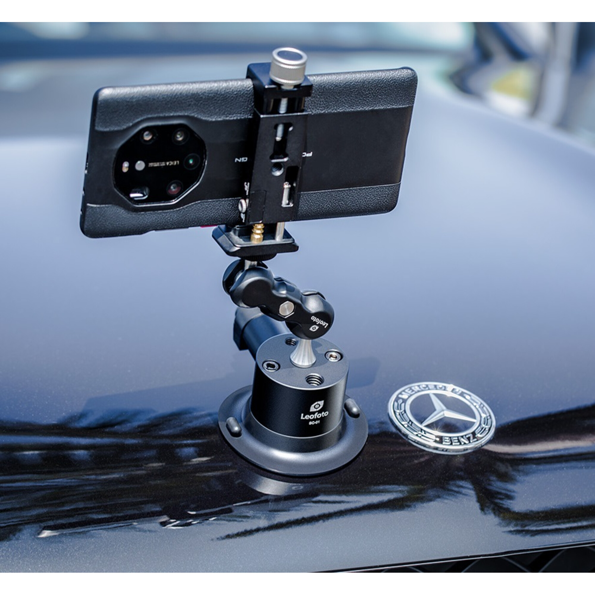 Ein Smartphone-Halter auf einem dunklen Auto mit Mercedes-Stern.