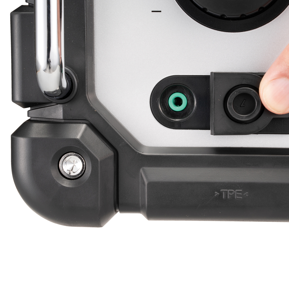 Zbliżenie uchwytu i portów głośnika. Palec naciska przycisk.