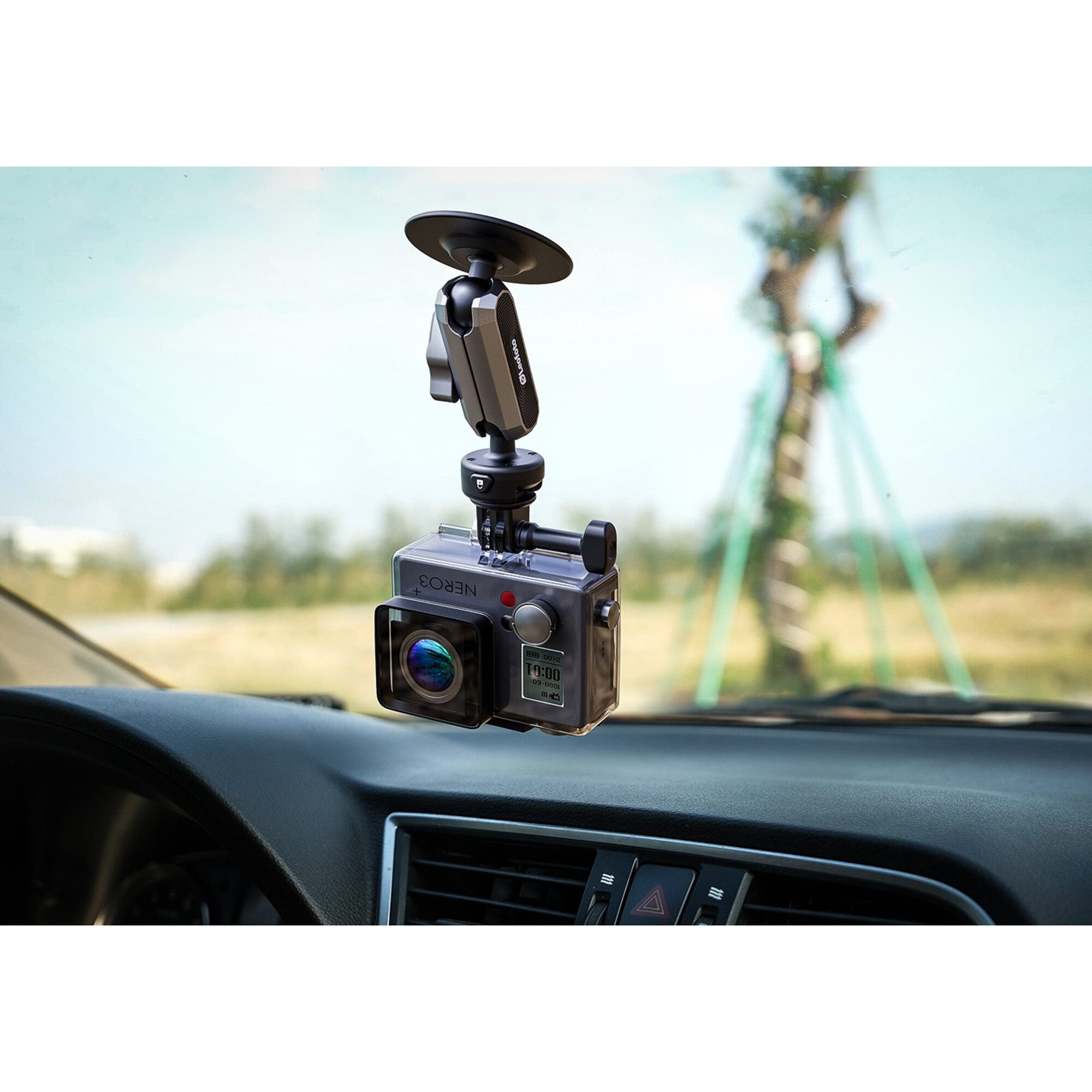 Eine Dashcam ist an einer Windschutzscheibe eines Autos montiert und zeigt eine unscharfe Außenansicht.