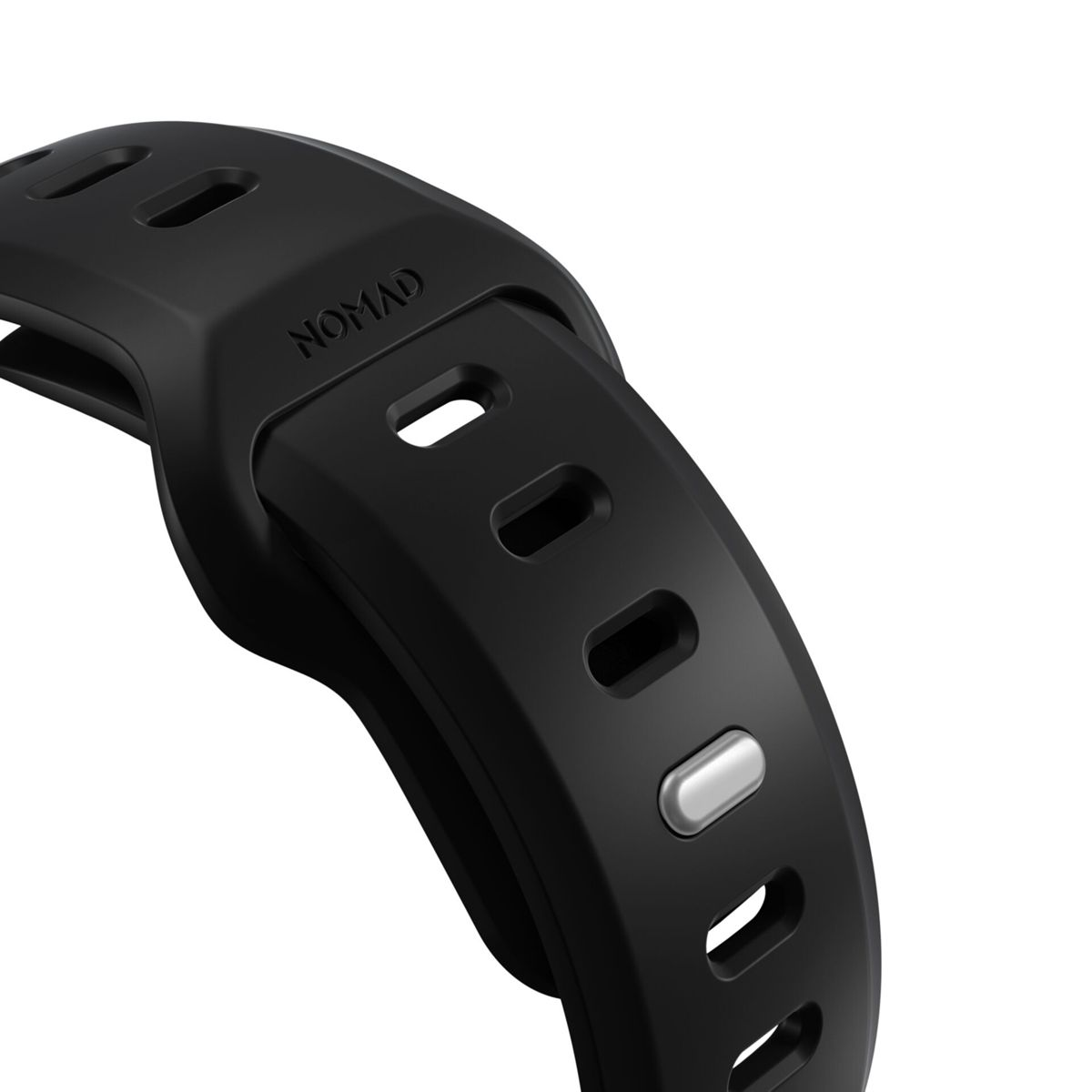 Primer plano de una correa de reloj Nomad negra con agujeros ovalados y un botón plateado.