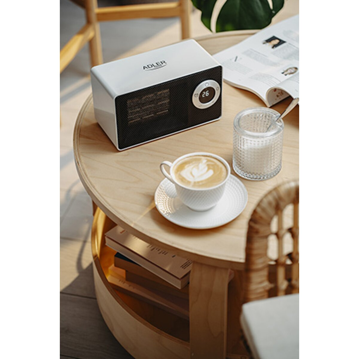 Ein weißer Adler-Heizer steht auf einem Holztisch mit Kaffee, Zucker und einer Zeitschrift.