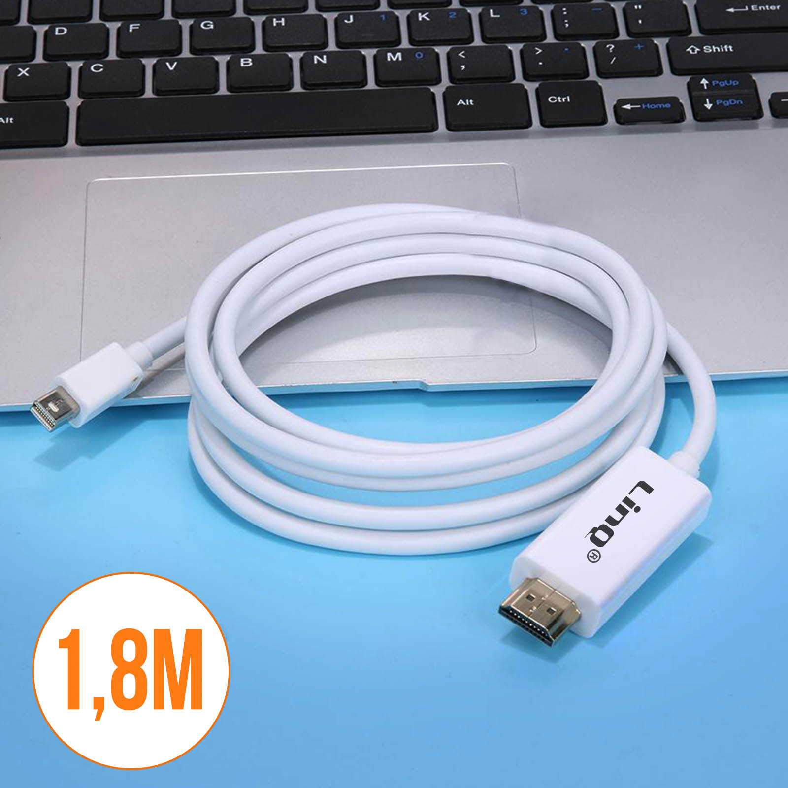 Un cavo bianco arrotolato con connettori HDMI e Mini DisplayPort poggia su un laptop.