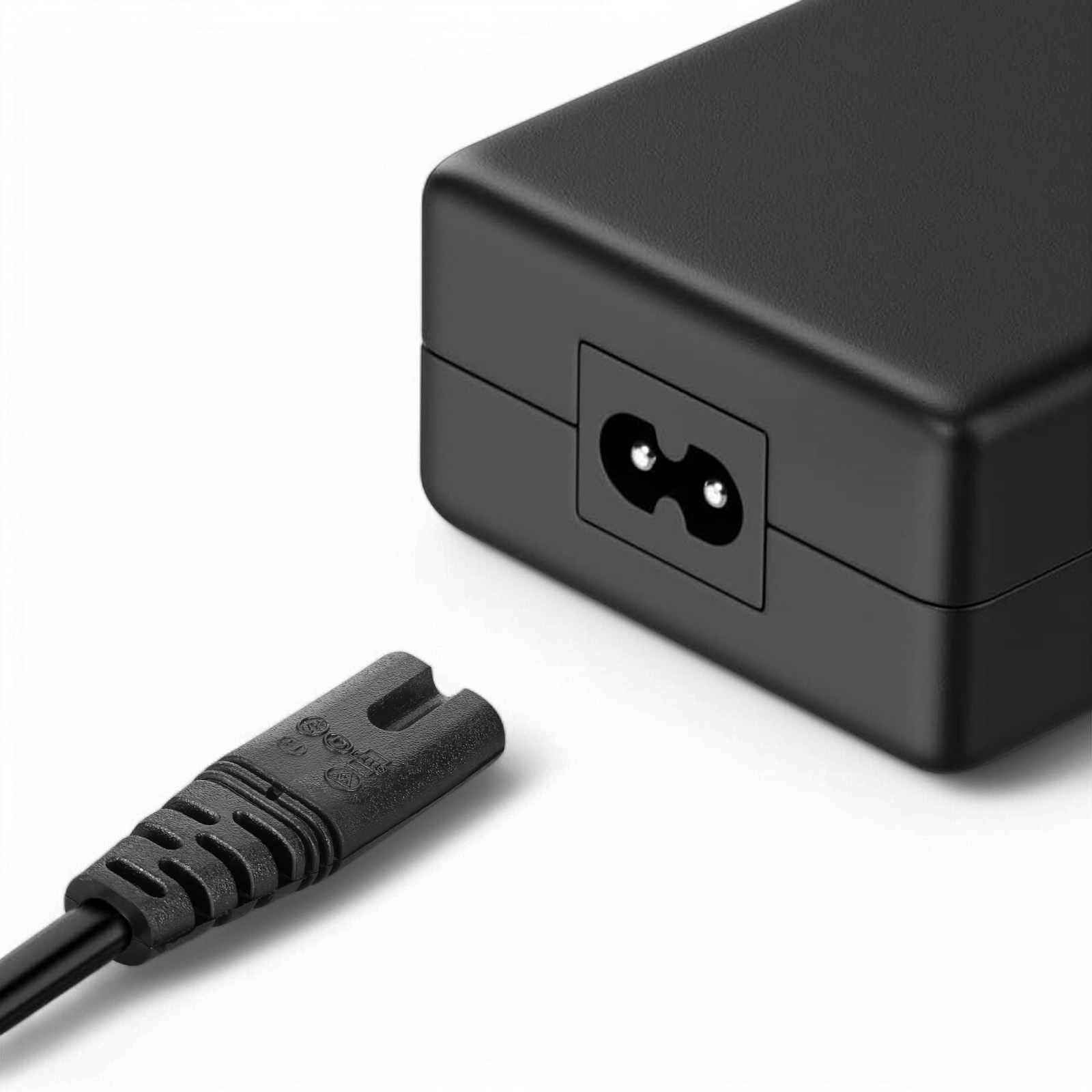 Un alimentatore nero con una spina bipolare accanto.