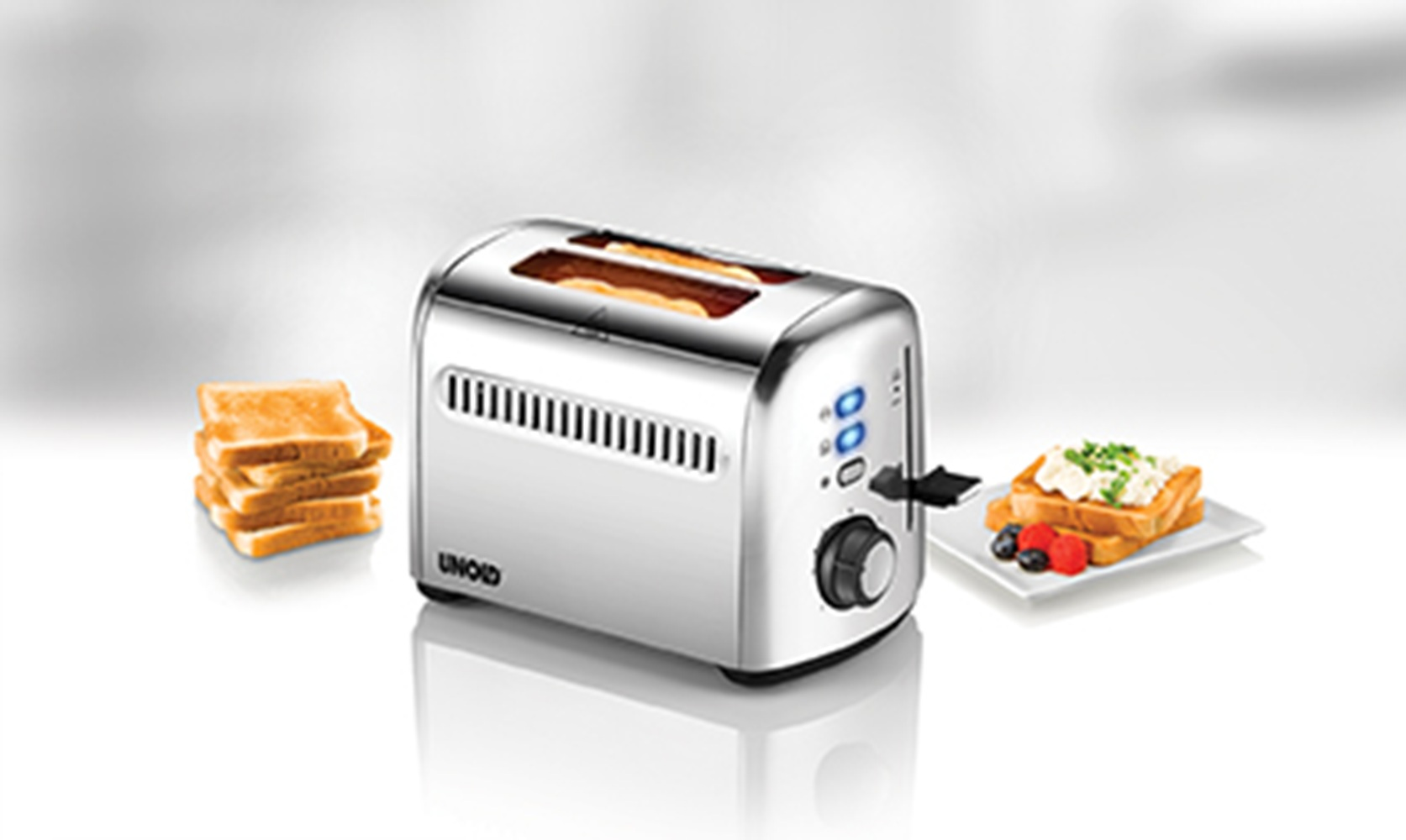 Ein Chrom-Toaster mit zwei Scheiben Brot, daneben ein Brothaufen und ein Teller Toast.