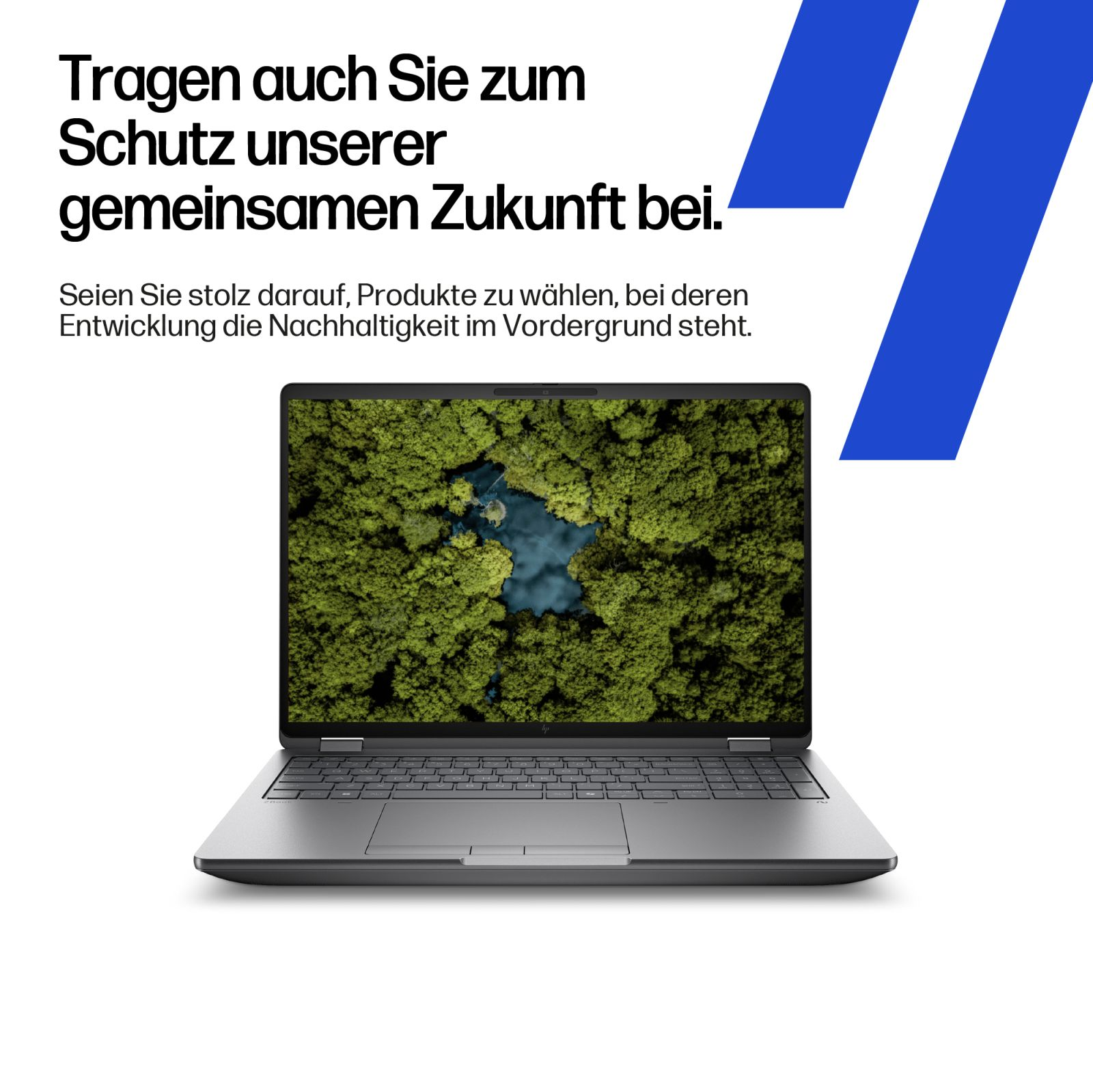 Laptop wyświetlający bujny zielony las z niebieskim jeziorem z lotu ptaka.