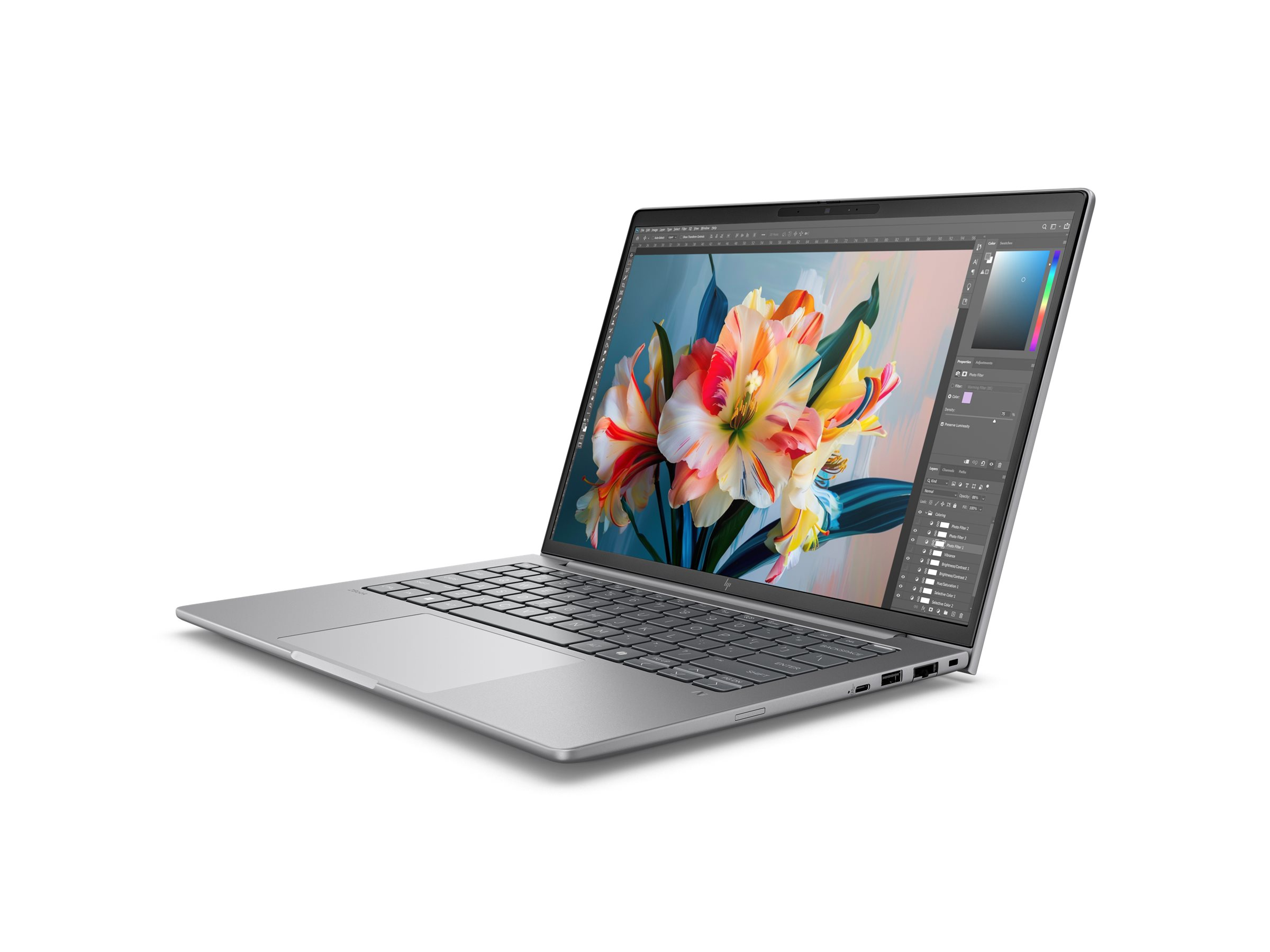 Srebrny laptop jest otwarty, wyświetla kolorowy obraz kwiatu i oprogramowanie edycyjne na ekranie.