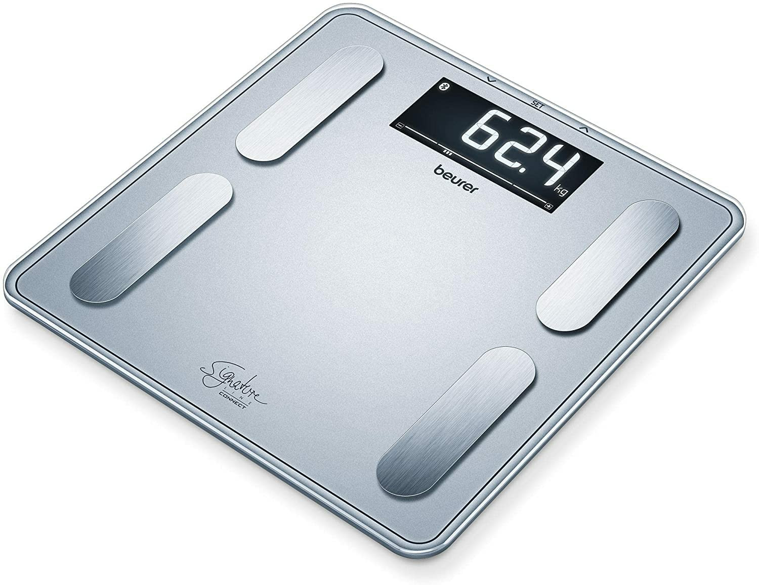 Eine silberne digitale Beurer-Waage zeigt 62,4 kg an, mit vier Metallfußpolstern.