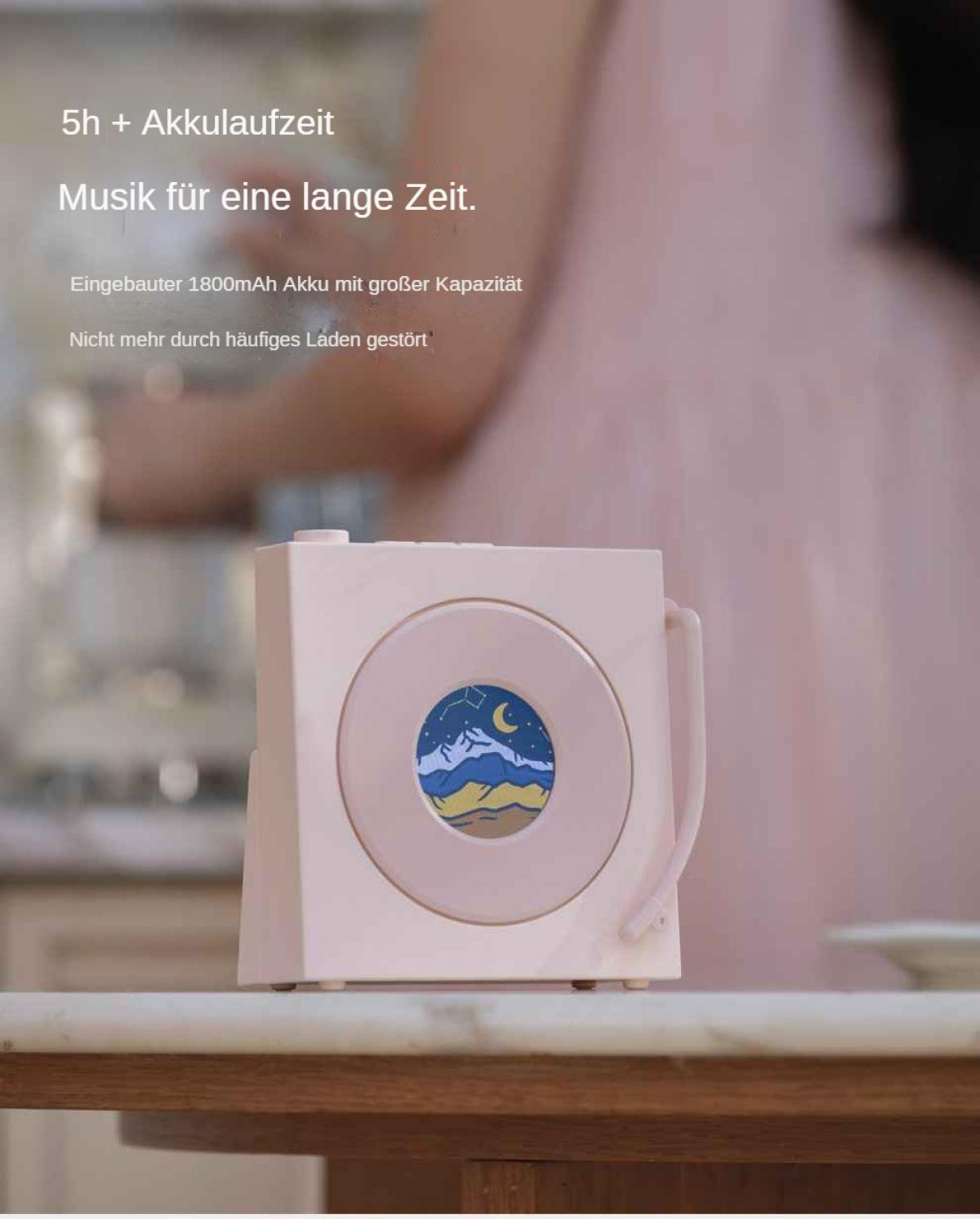 Ein pinker Lautsprecher mit Berg- und Mondgrafik steht auf einem Tisch.