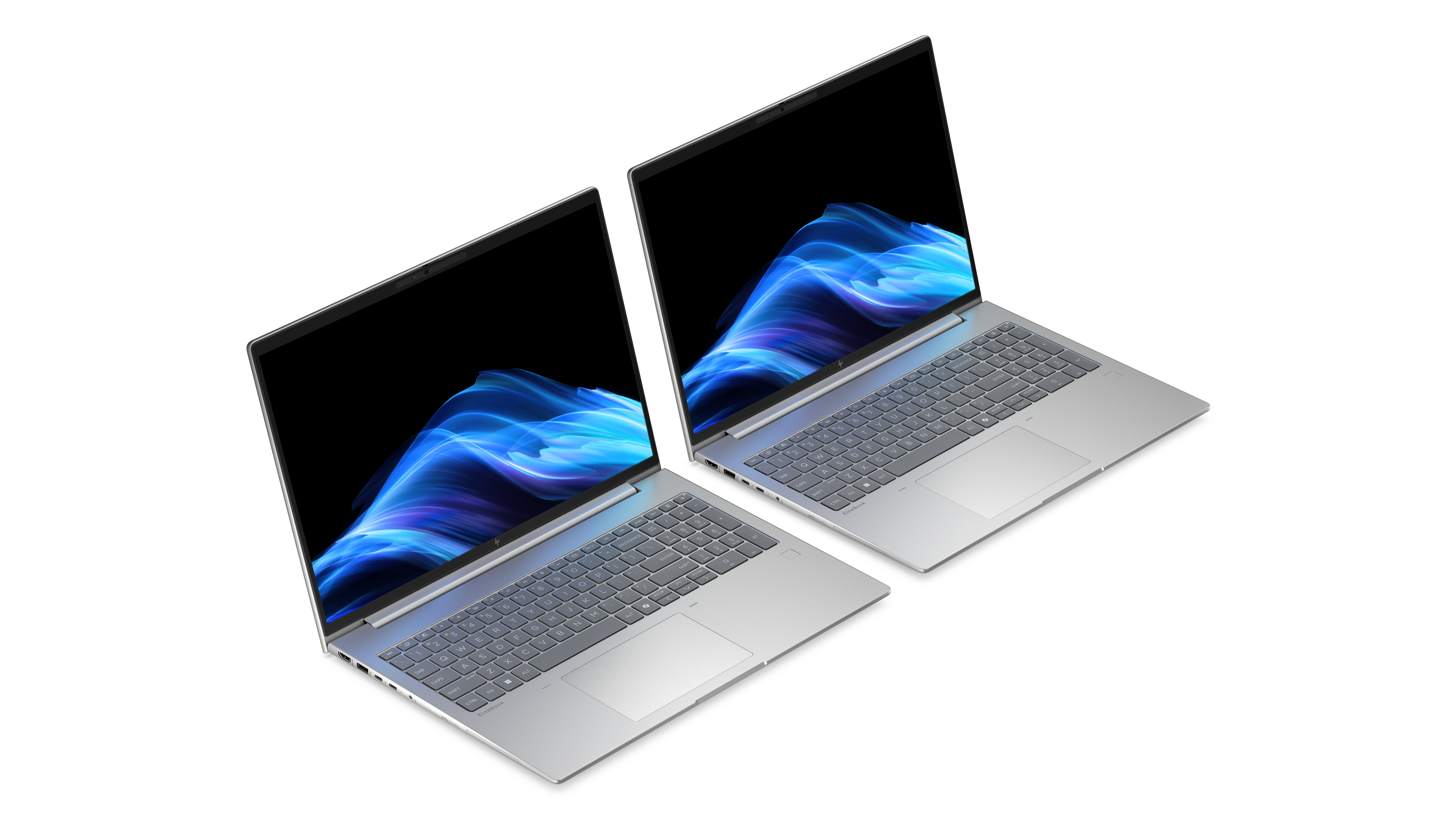 Due laptop argentati uno accanto all'altro che mostrano sfondi astratti blu sullo schermo.