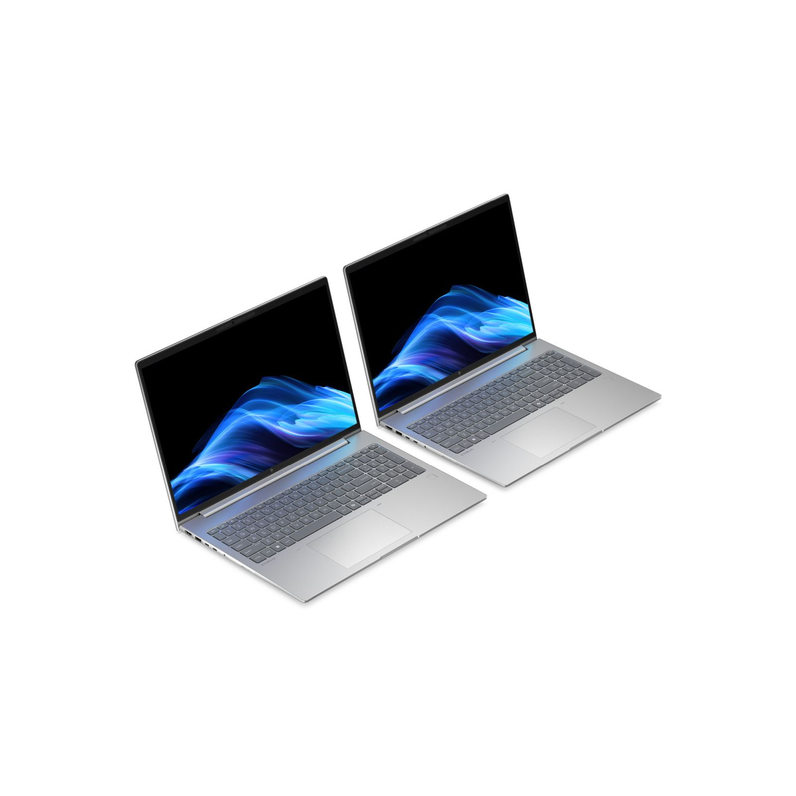 Due laptop argentati con sfondi blu e ondulati sugli schermi.