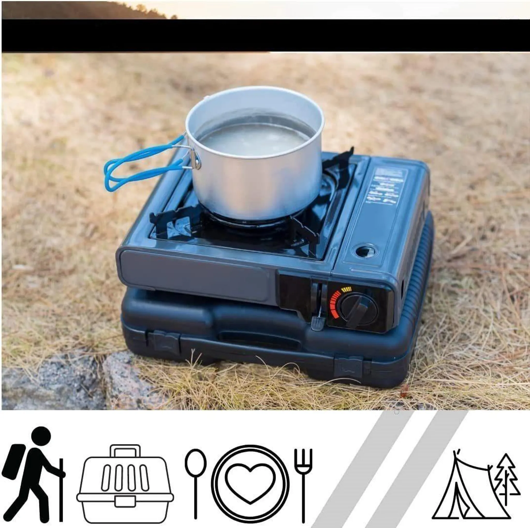 Ein Campingkocher erhitzt Wasser in einem Topf auf trockenem Gras.