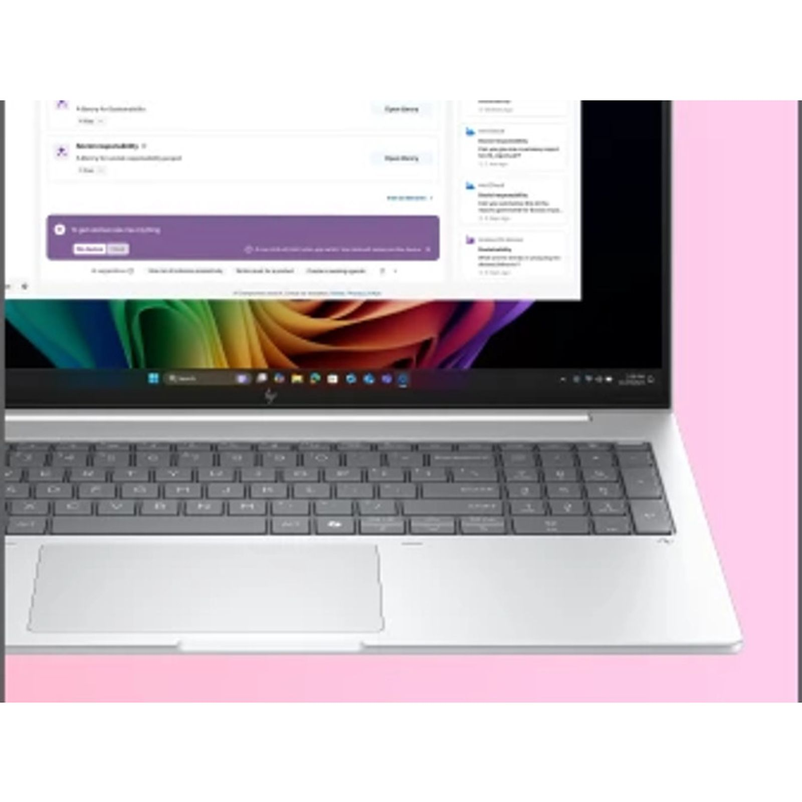 Un laptop argentato mostra uno schermo con sfondo astratto colorato e un'interfaccia utente.