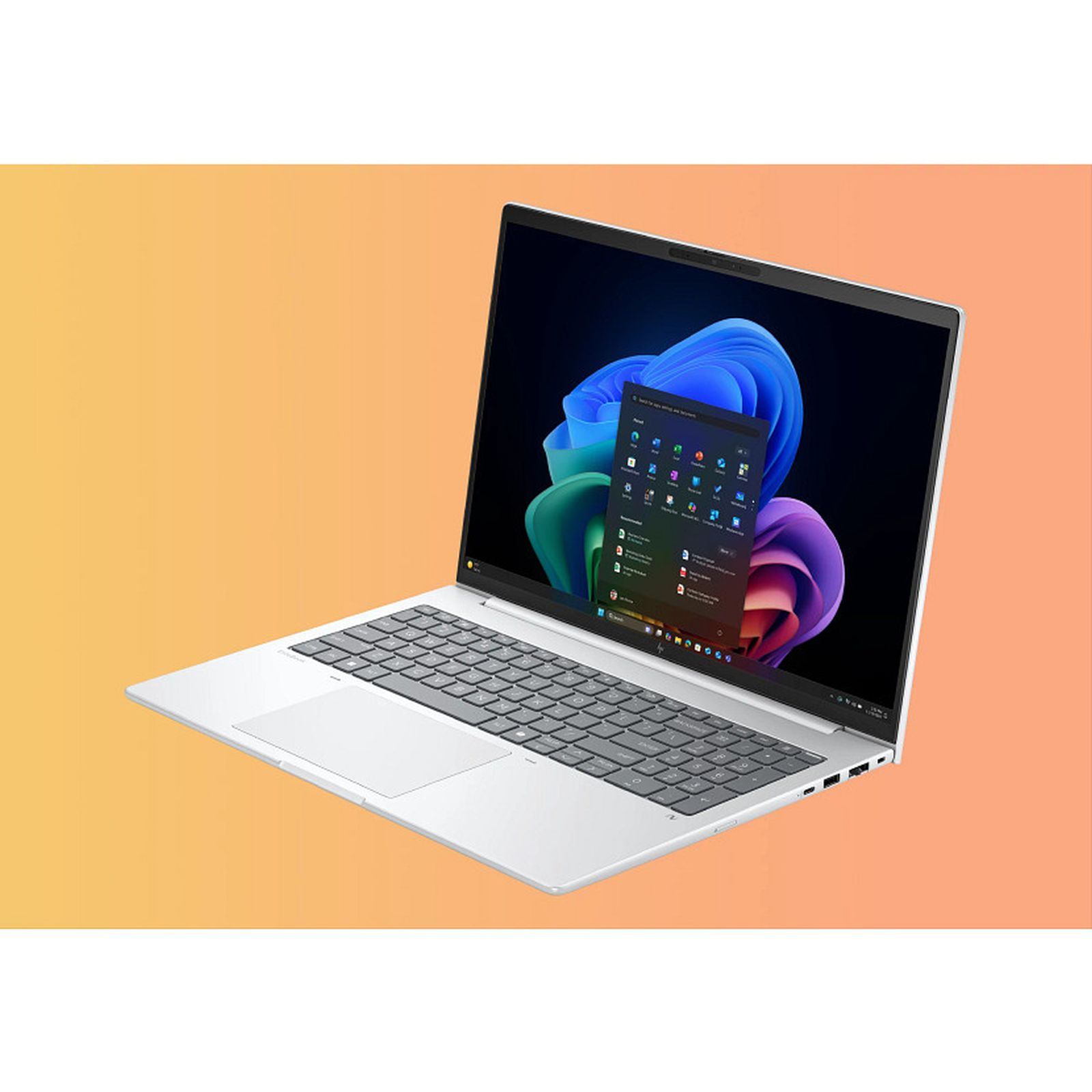 Un laptop argentato che mostra uno sfondo e un menu Start di Windows 11 vivaci.