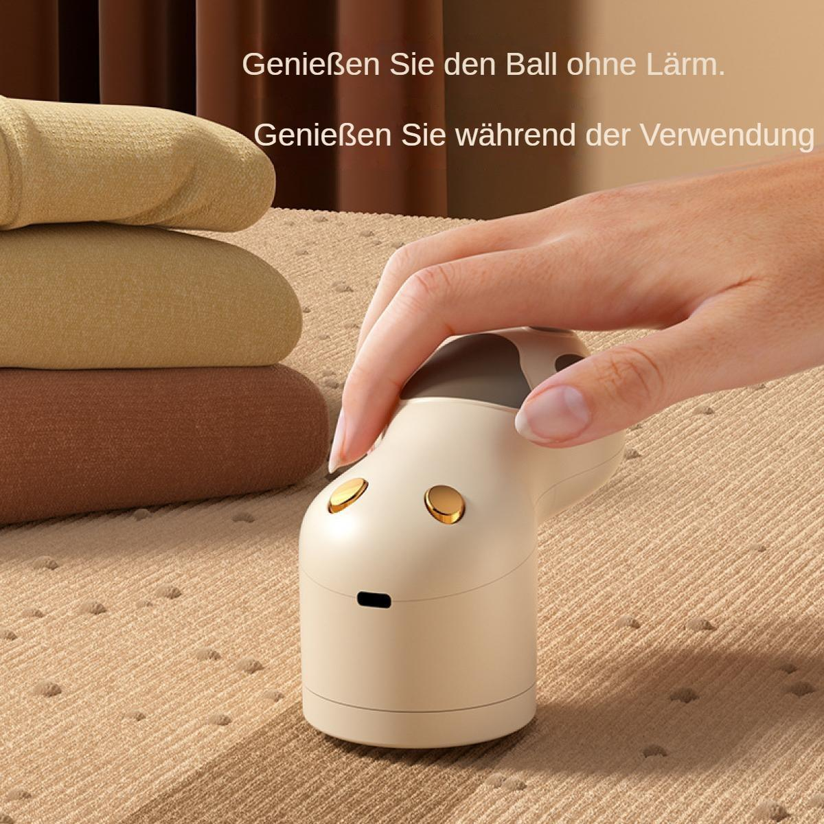 Eine Hand bedient einen beigefarbenen Stoffrasierer neben gestapelten Stoffen.