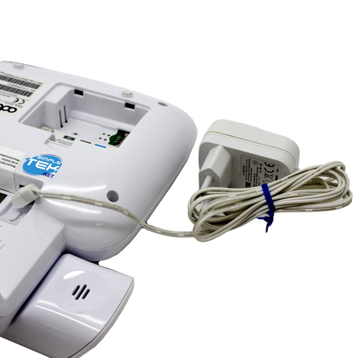 Base telefono cordless bianca con adattatore CA collegato. Scomparto batteria aperto.
